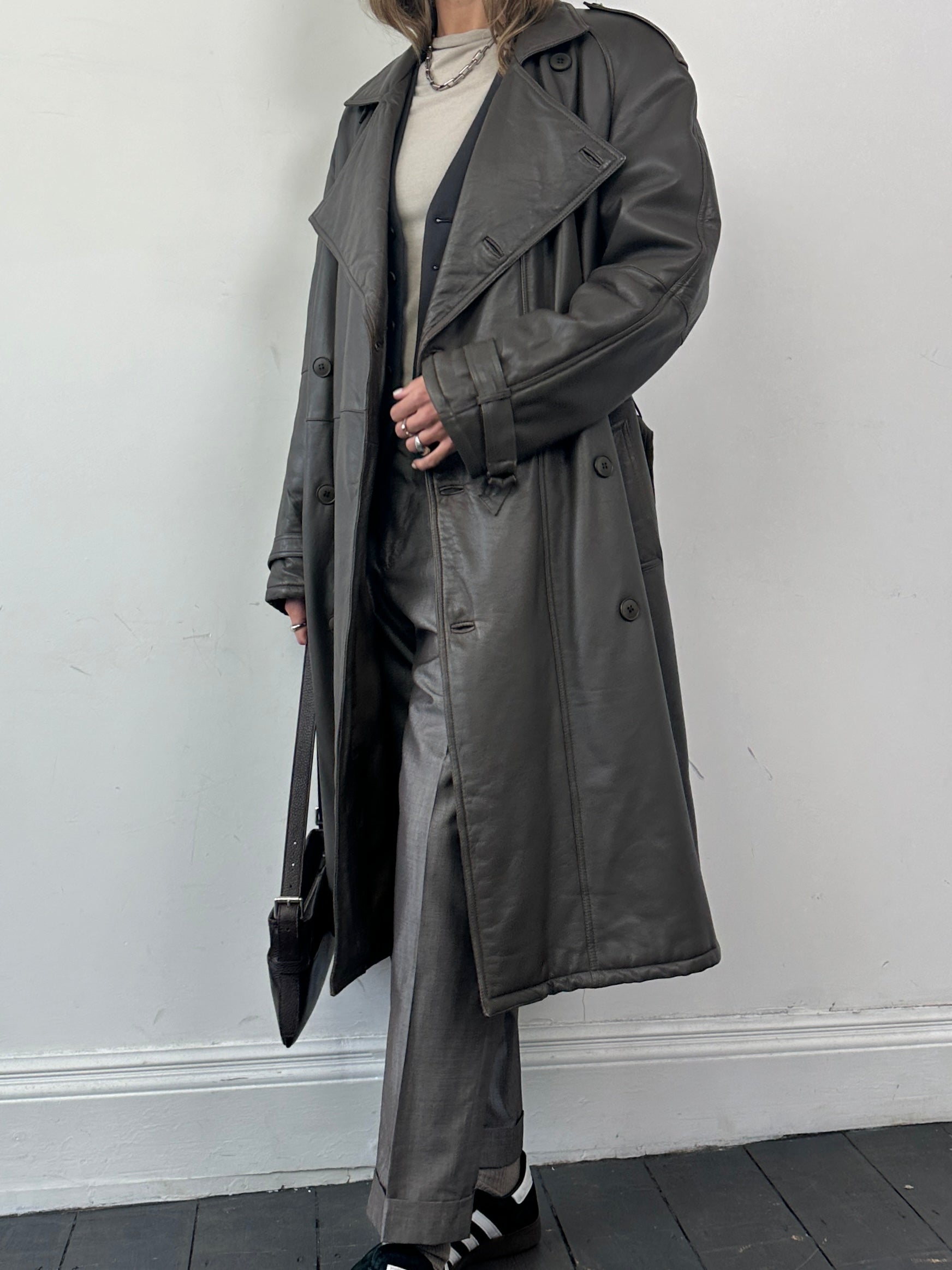 Vintage leather double-breasted belted trench coat, stylish and classic, shown in size L with detailed collar and button closure.