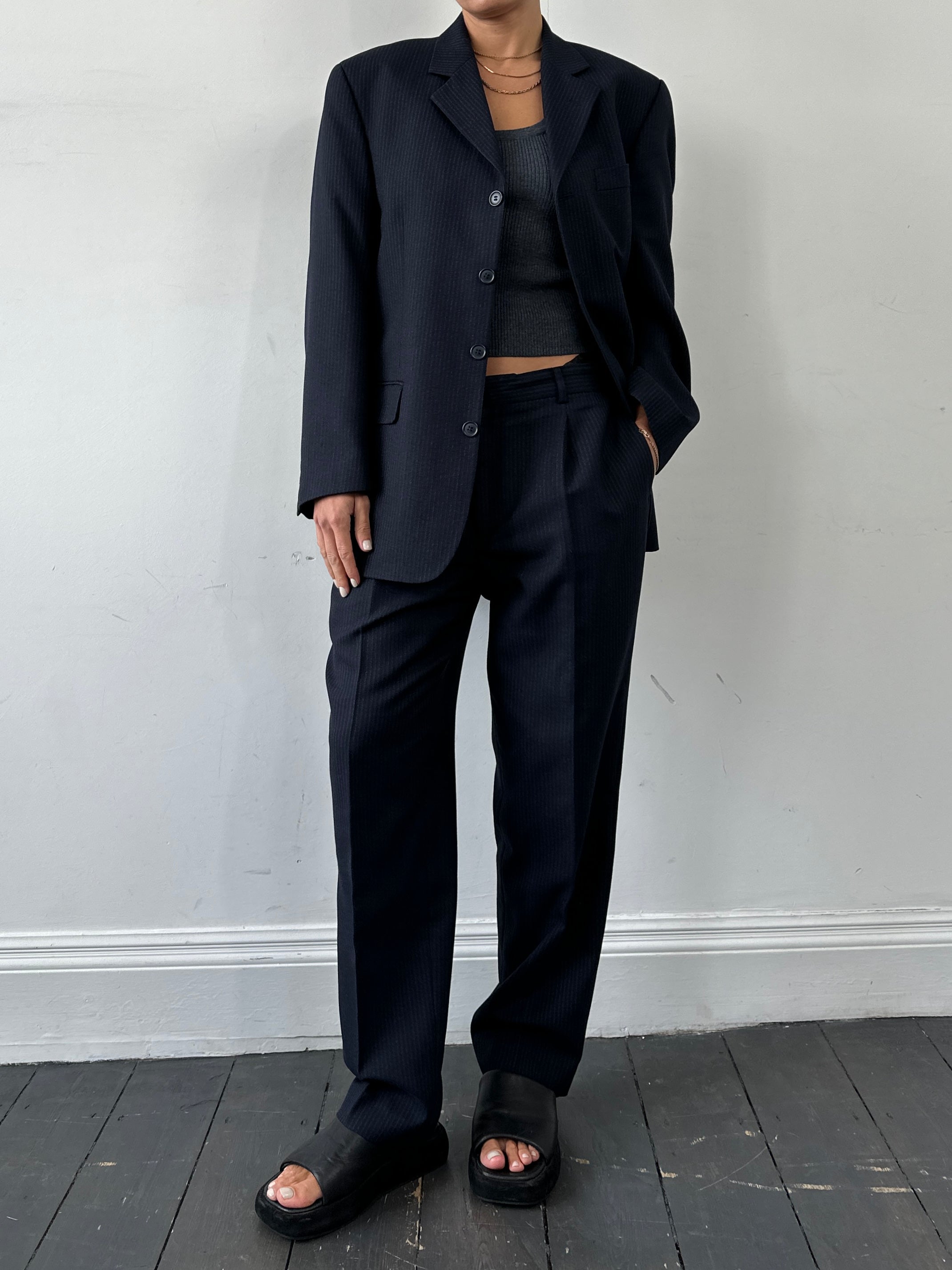Vintage pinstripe wool jumpsuit, single-breasted suit in size 40R/W34, displayed on a hanger with detailed pinstripe fabric.