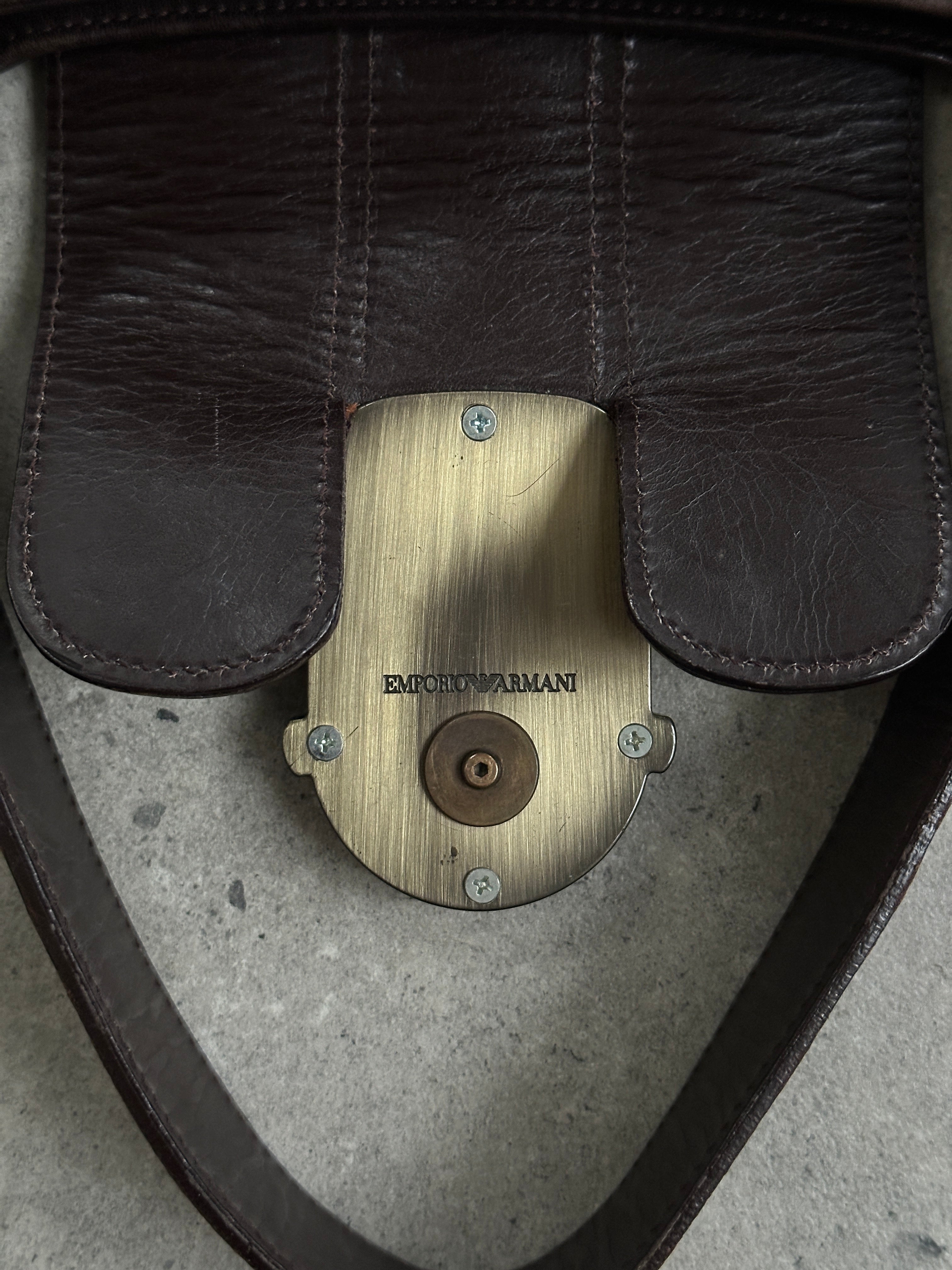 Emporio Armani leather shoulder bag with hardware monogram design, featuring a sleek strap and elegant branding.
