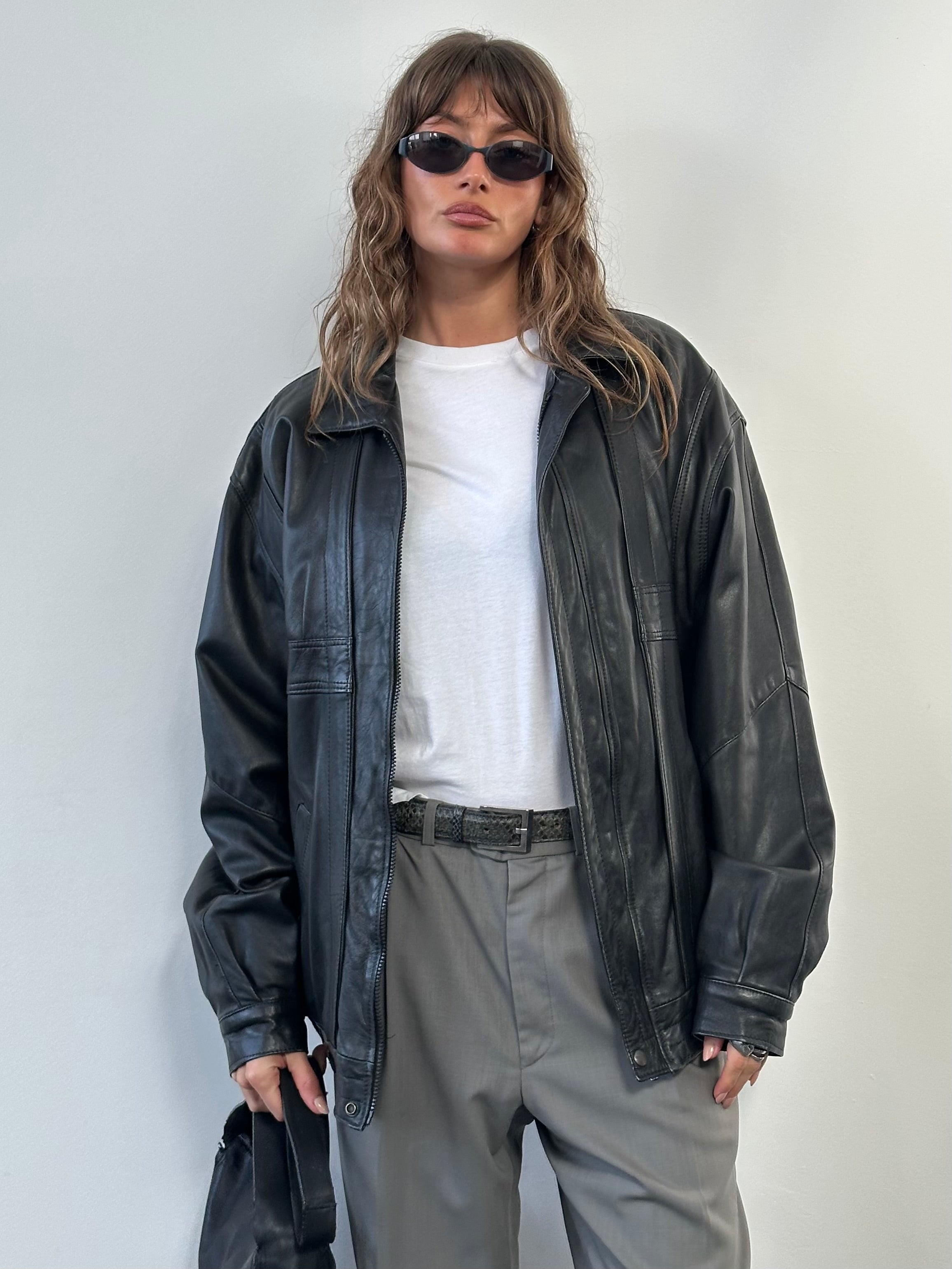 Vintage 1990s leather bomber jacket in XL, showcasing classic design with a worn-in leather look and ribbed collar and cuffs.