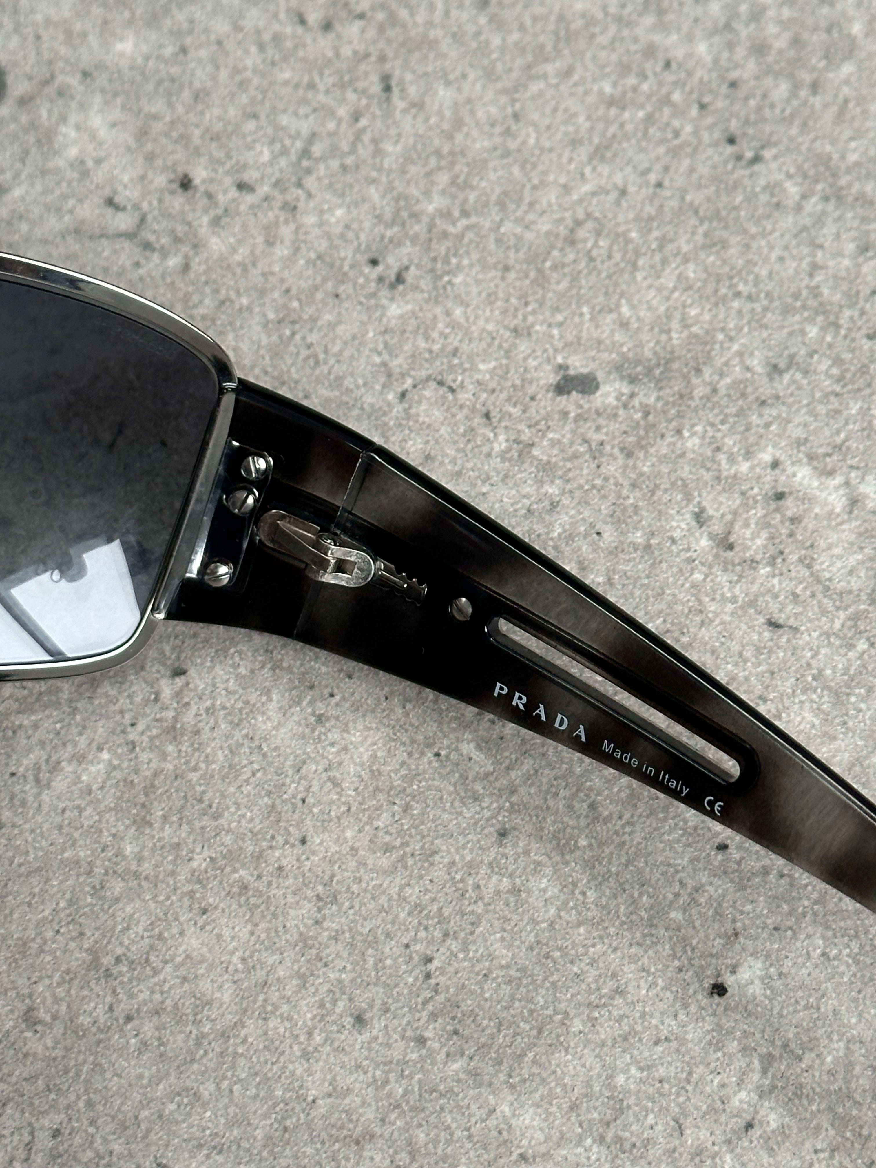 Prada 2000s aviator shield sunglasses with reflective lenses and metal frame, stylish eyewear from the luxury fashion brand.