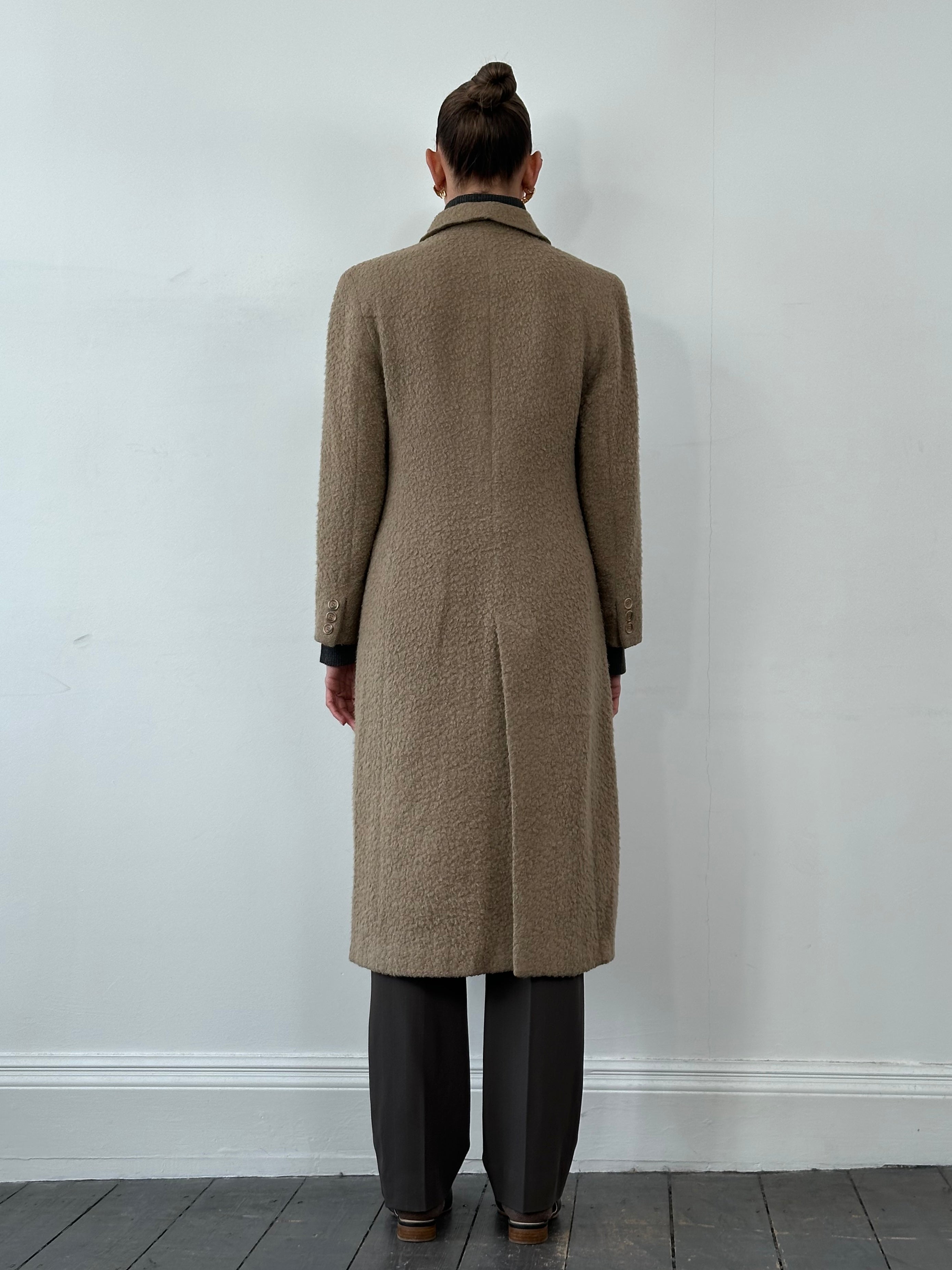 Giorgio Armani 1990s wool single-breasted coat in size M, shown hanging with classic tailored design and neutral color.