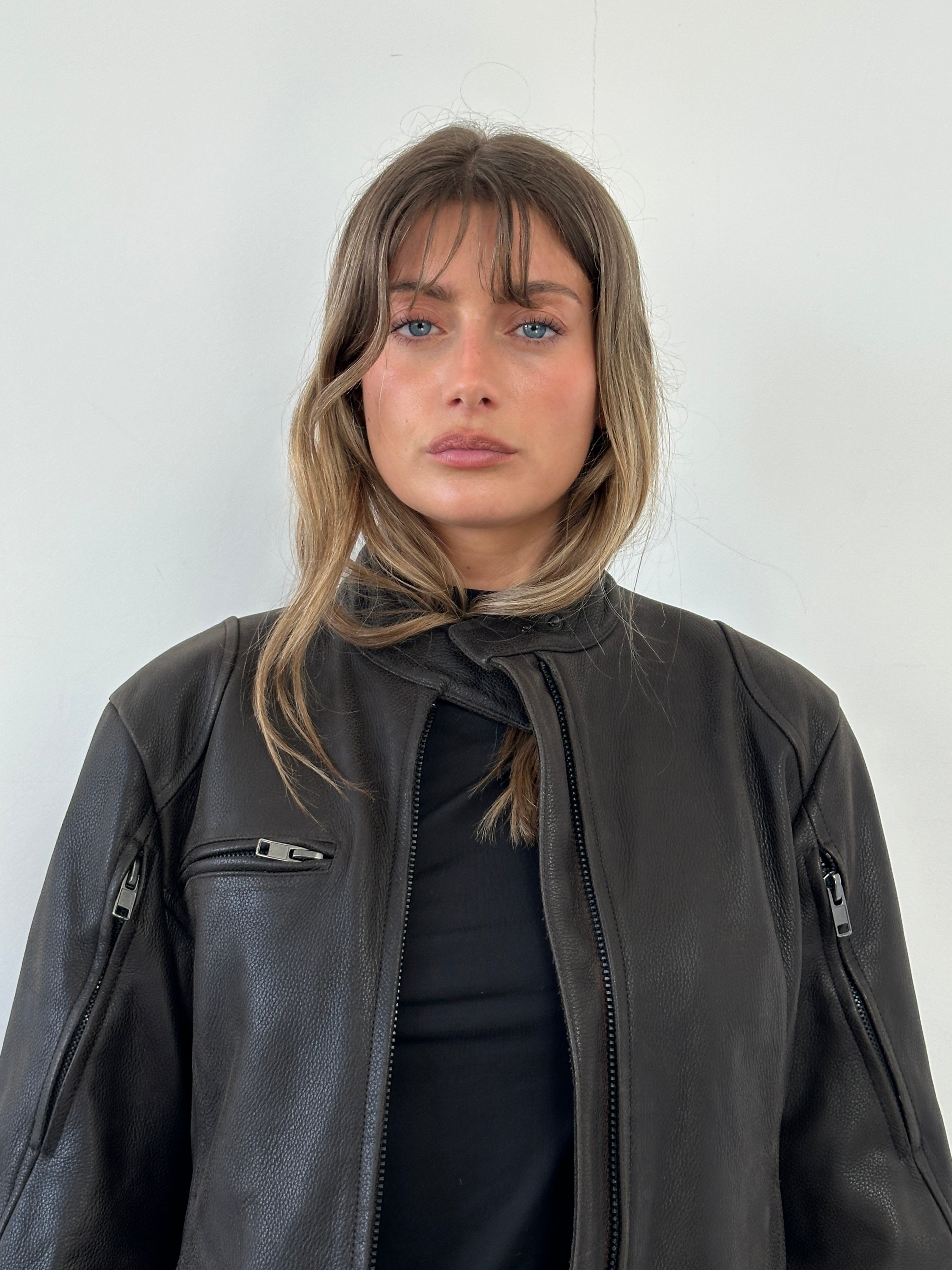 Vintage leather moto jacket in size S/M featuring classic design, shoulder epaulets, and front zipper details.