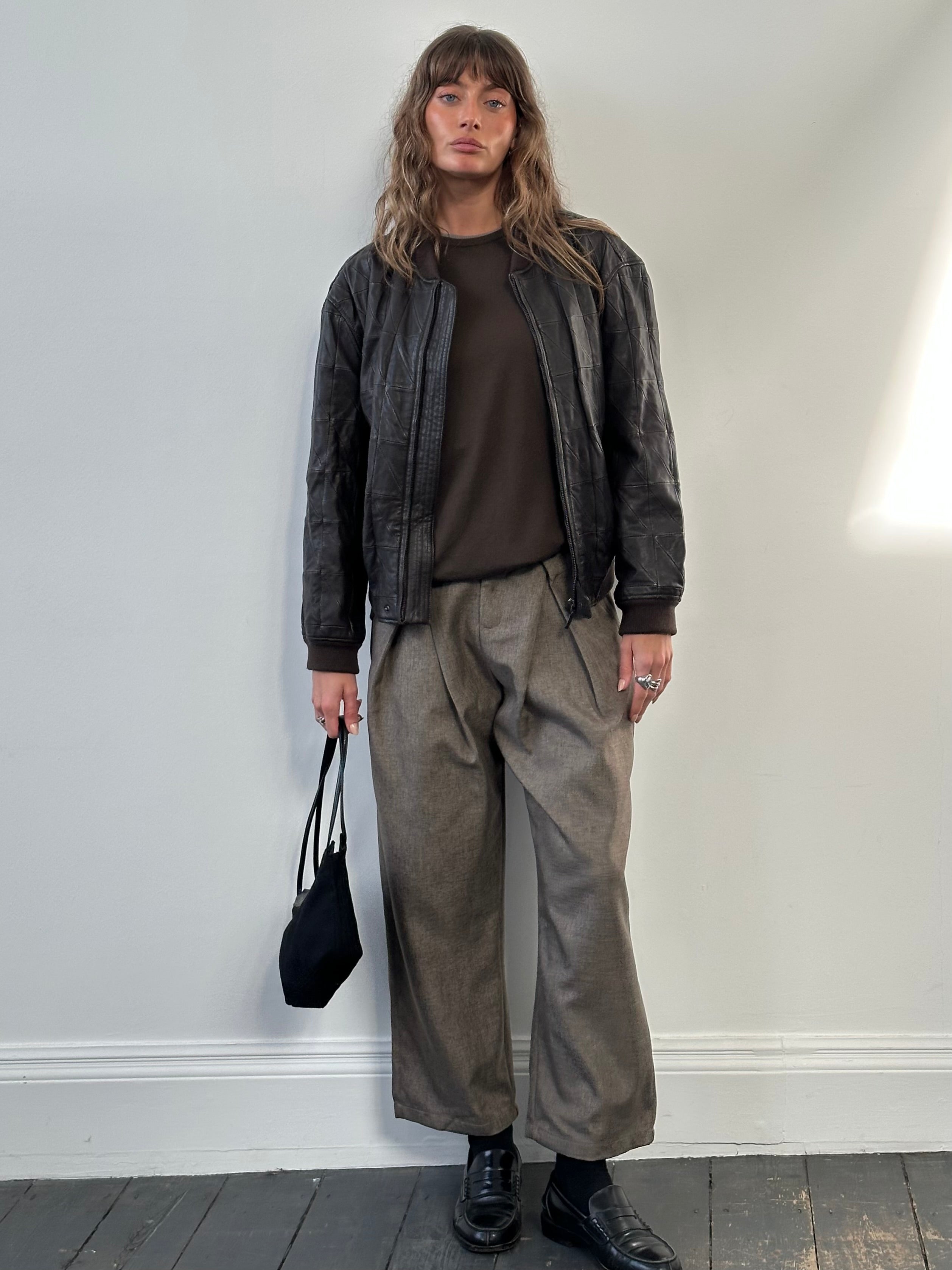 Armani Collezioni 2000s leather bomber jacket in black, featuring classic design and ribbed cuffs, size S/M.