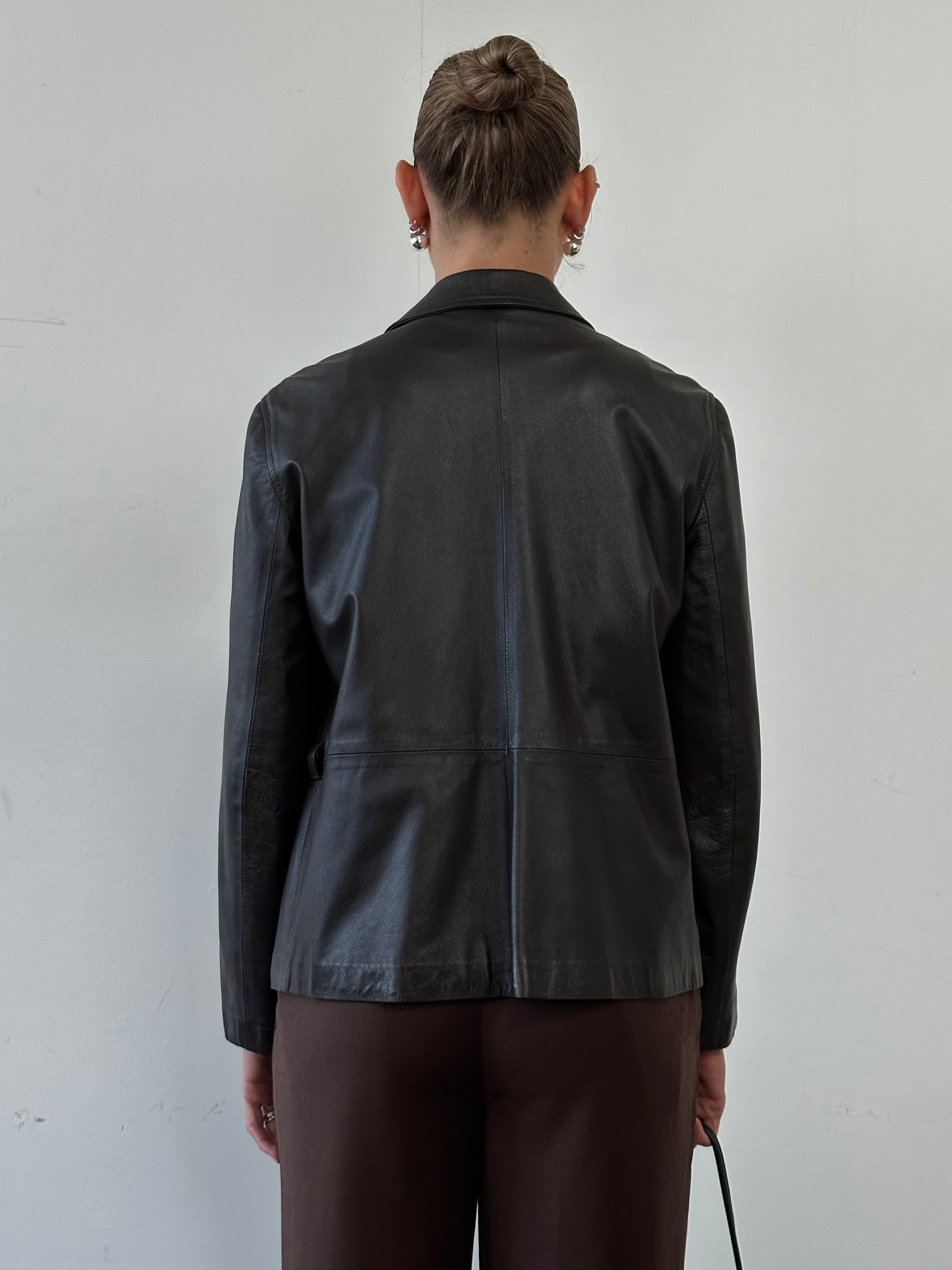 Giorgio Armani Black Label belted leather jacket in black, featuring a classic design with a front belt and sleek leather finish.