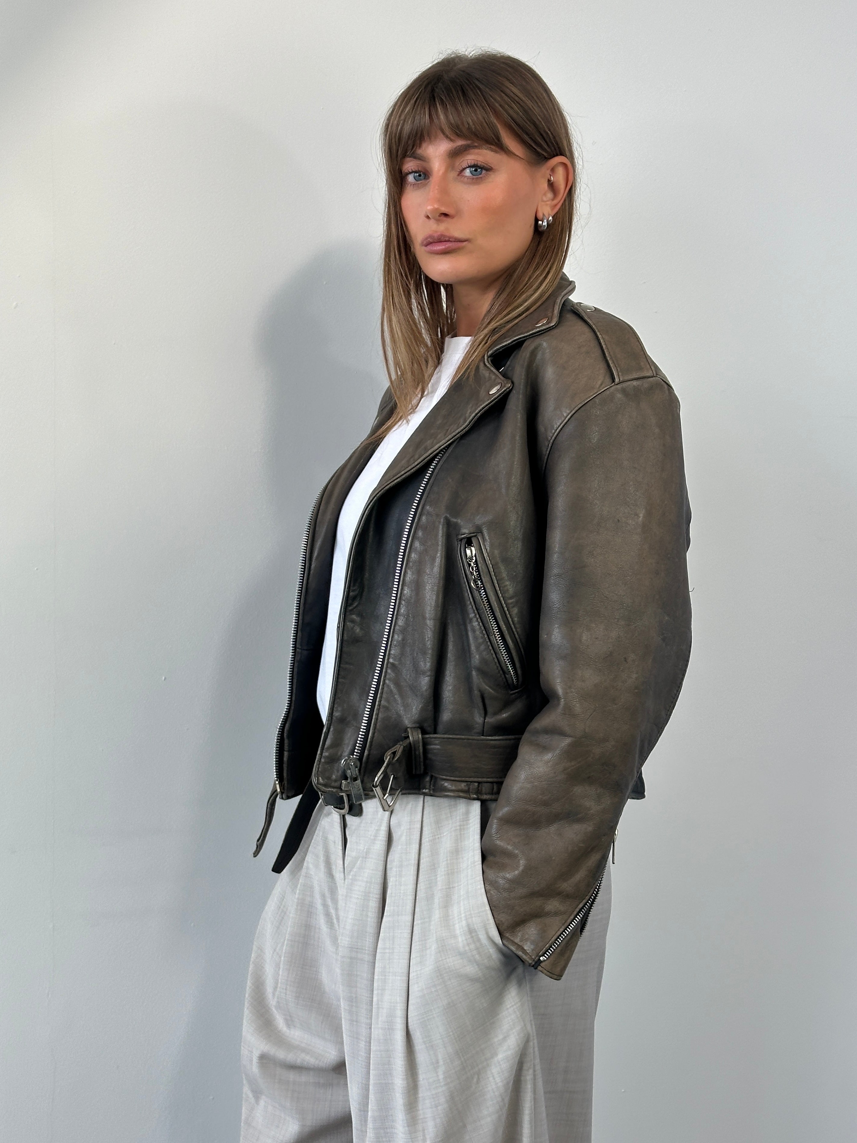 Vintage 1980s distressed leather biker jacket in size small, featuring rugged design and classic motorcycle style.