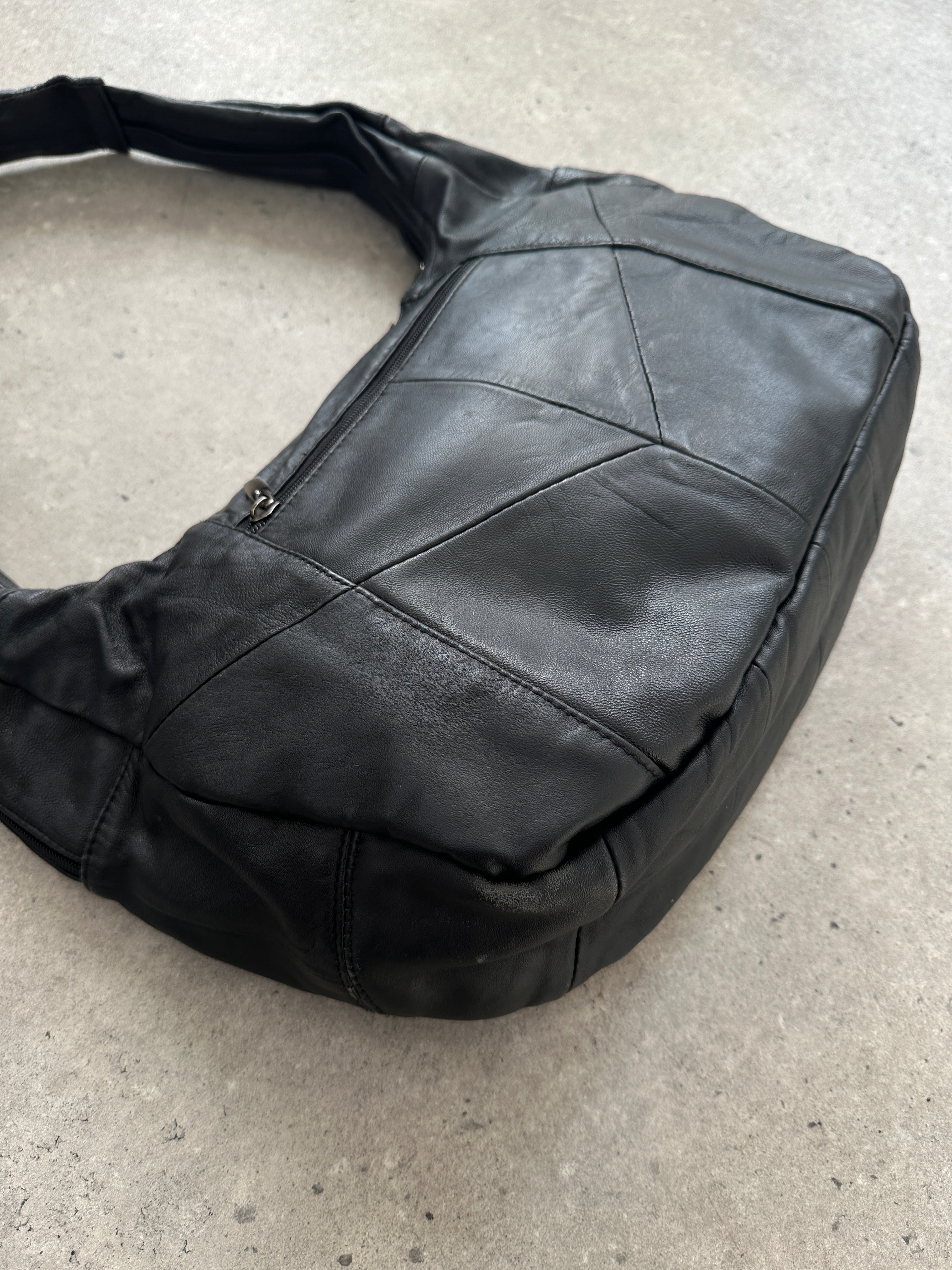 Vintage leather patchwork sling crossbody bag with adjustable strap and multiple compartments, stylish and functional accessory.
