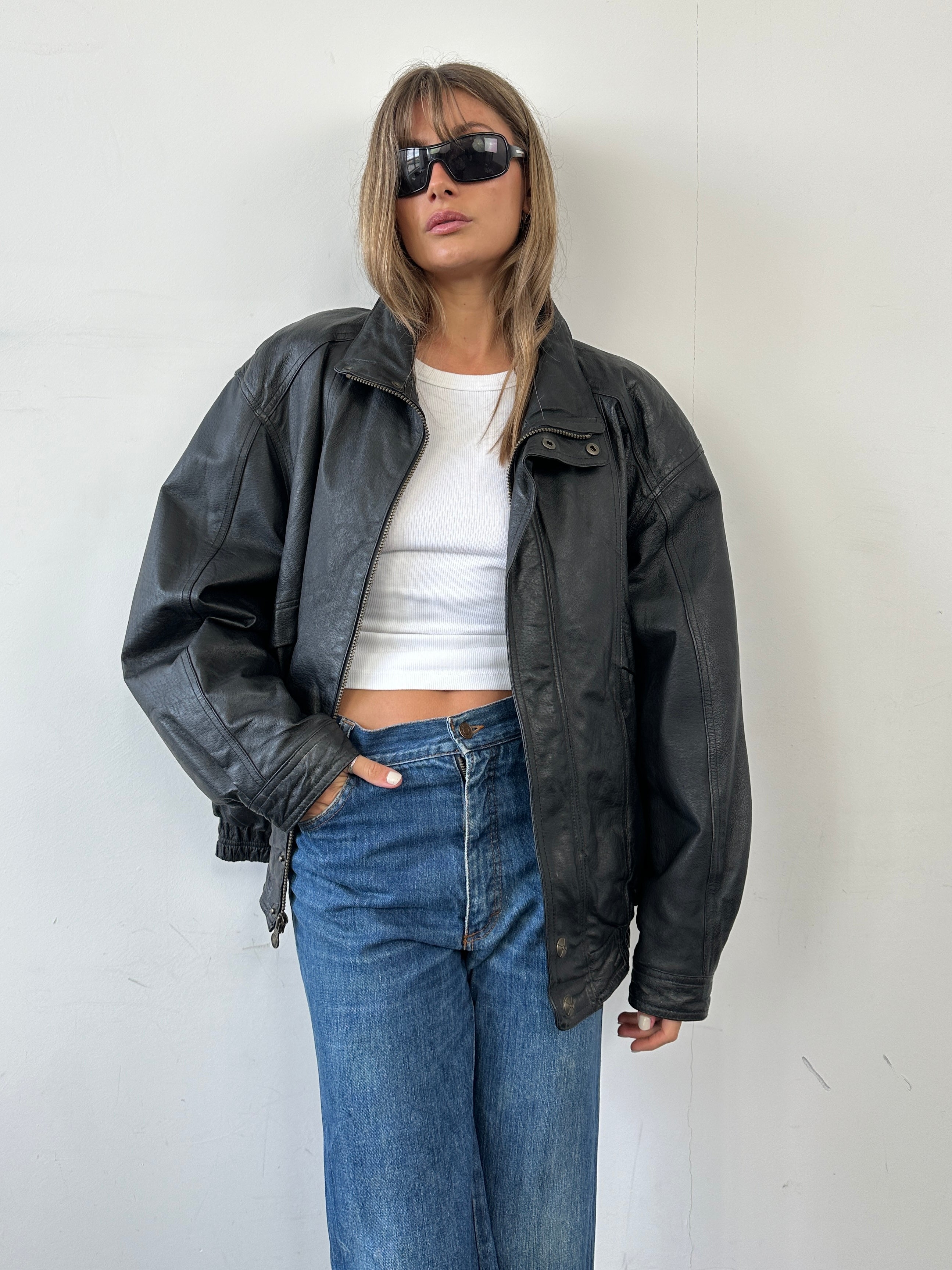 Vintage leather bomber jacket in XL size, featuring classic design with ribbed cuffs and collar, styled for a timeless look.