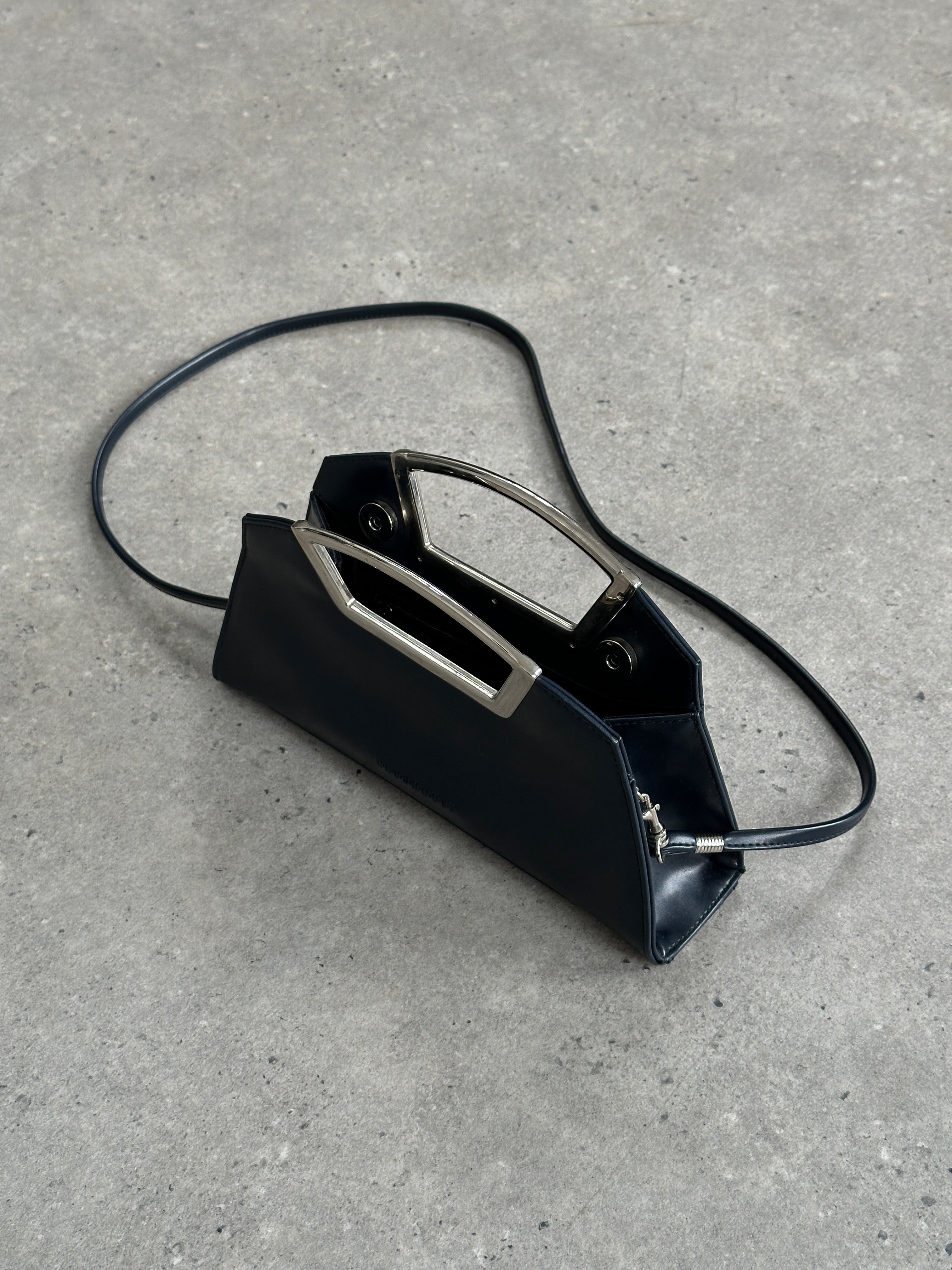 Vintage leather chrome crossbody clutch bag with a sleek, timeless design and metallic accents for versatile style.
