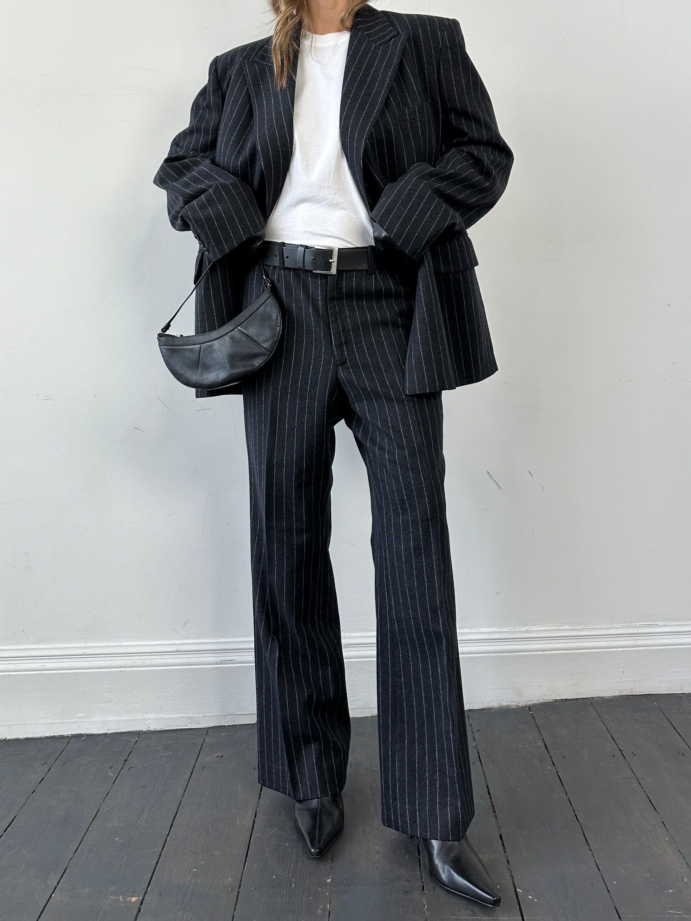 Christian Dior wool double-breasted pinstripe jumpsuit with tailored fit and long sleeves, showcased on a hanger.