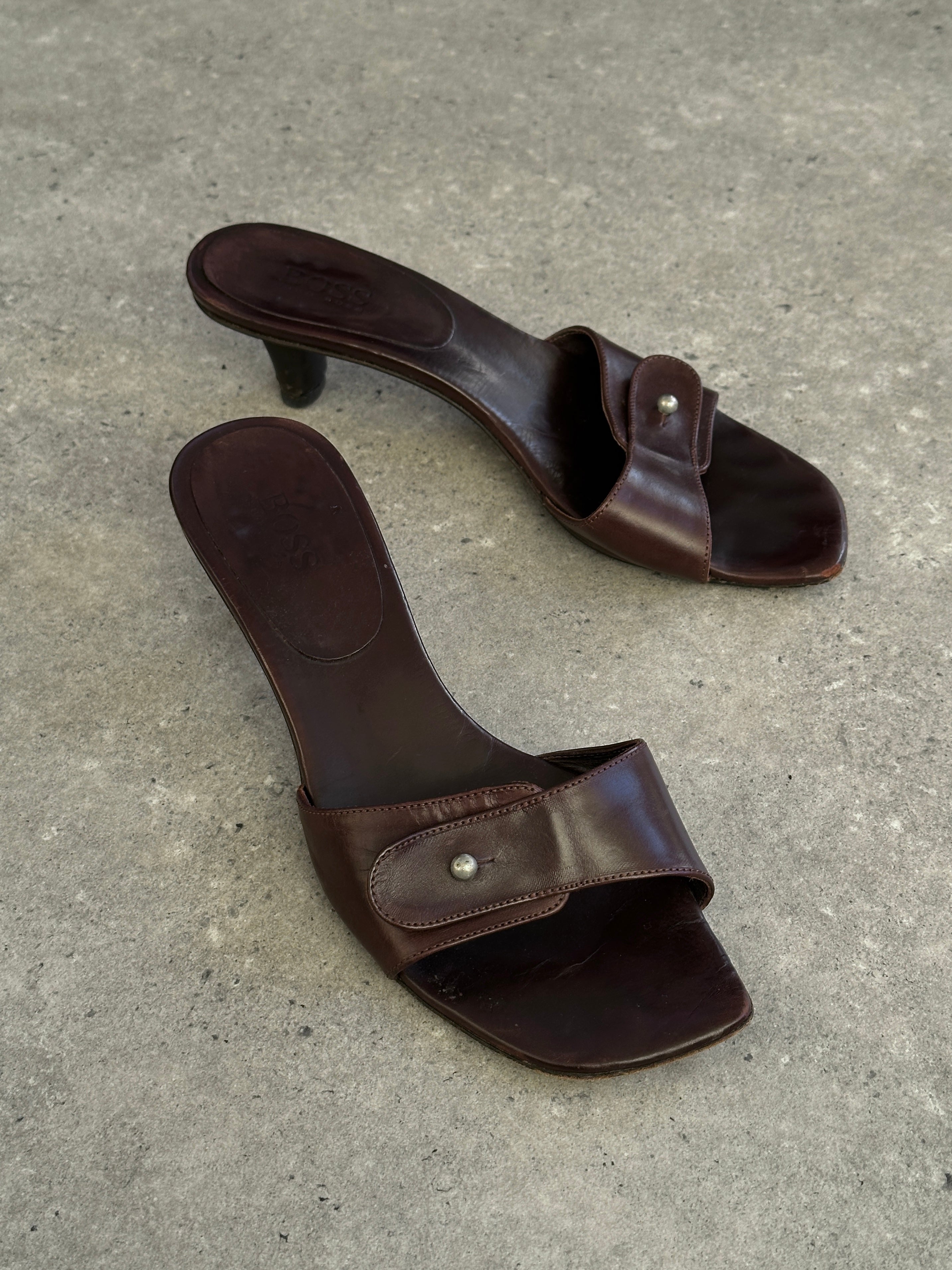 Hugo Boss leather mules in UK size 5, EUR 38, featuring sleek black leather and stylish slip-on design.