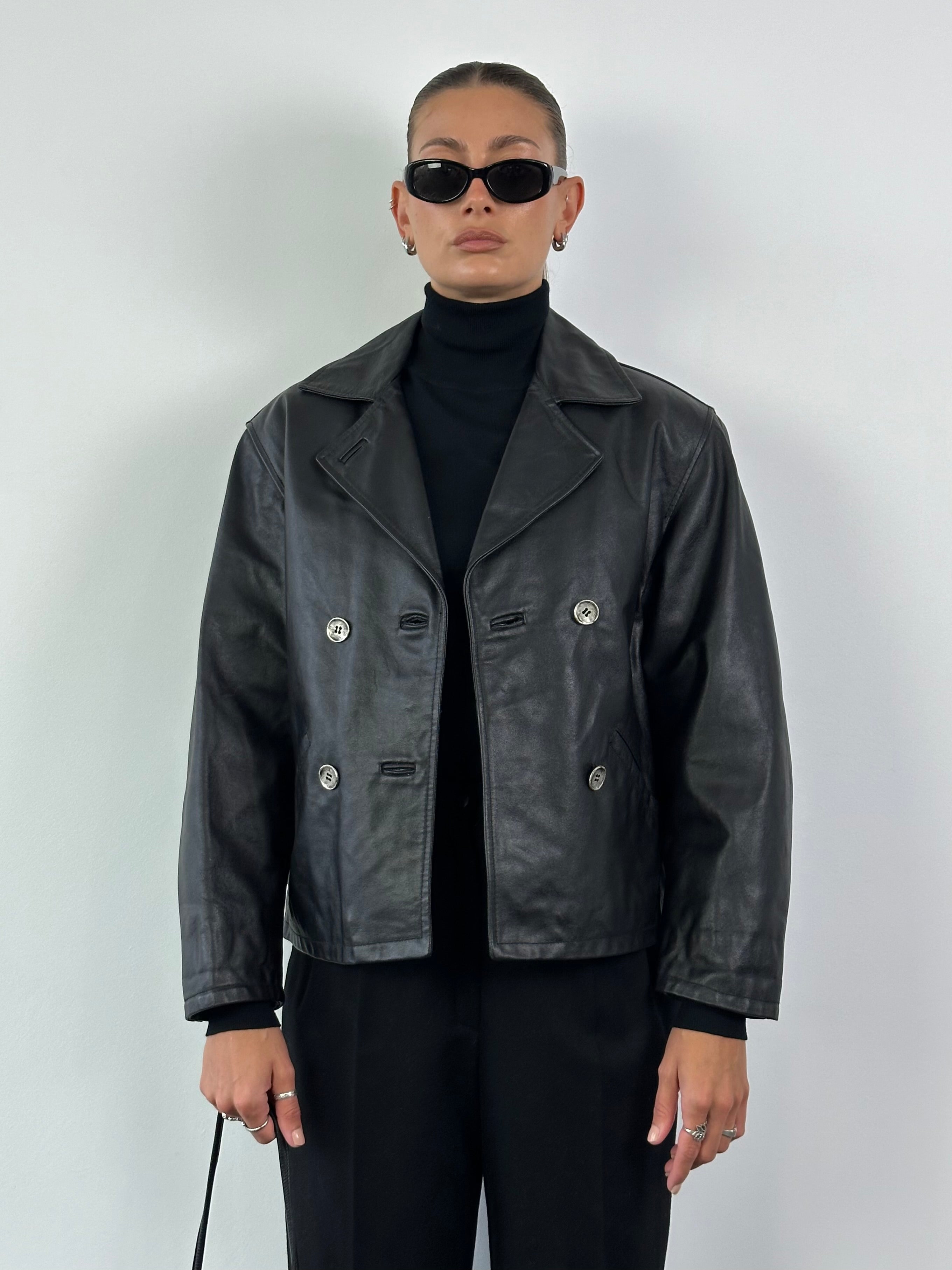 Vintage Italian leather jacket, cropped double-breasted style, in classic design with lapels and button details.