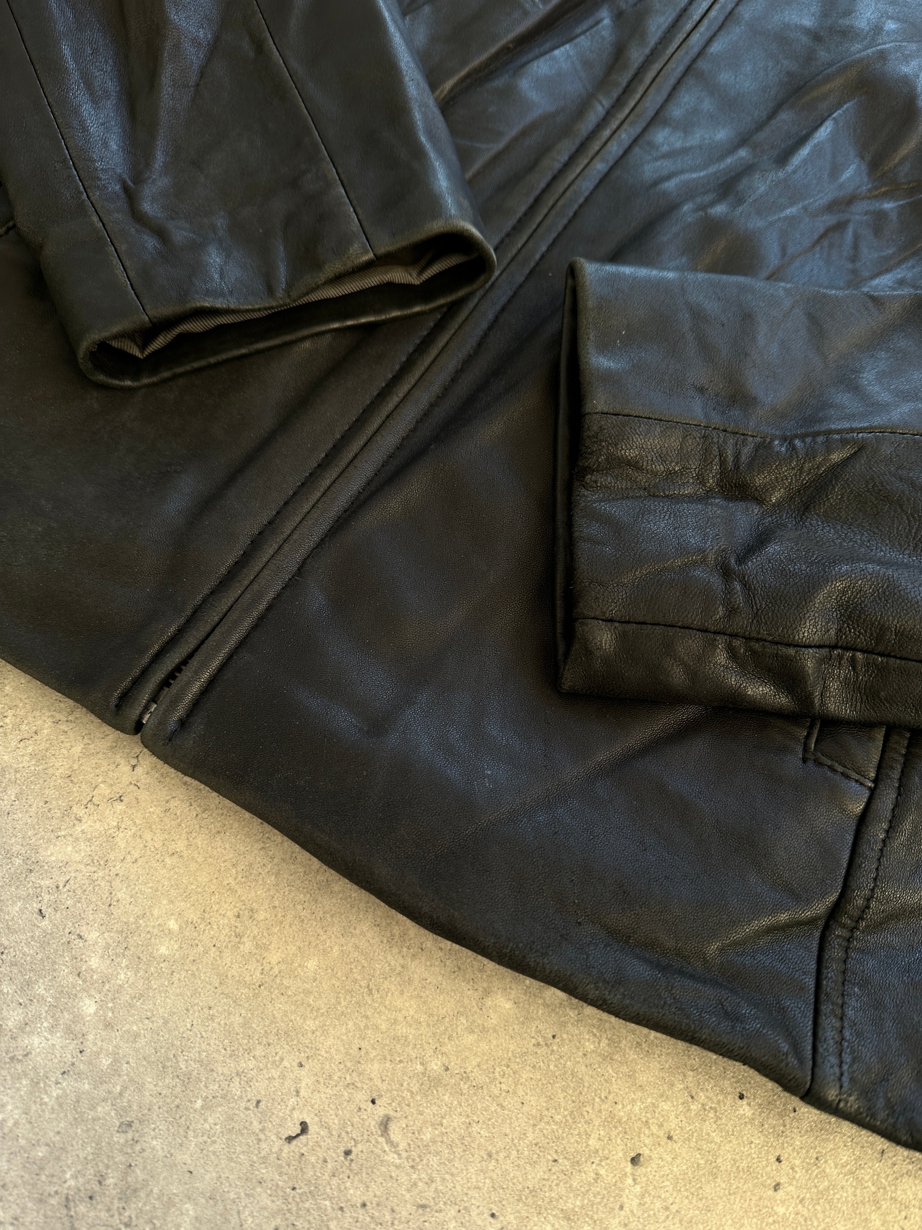 Vintage minimal leather jacket in size M/L, featuring classic design and high-quality leather, displayed on a hanger.