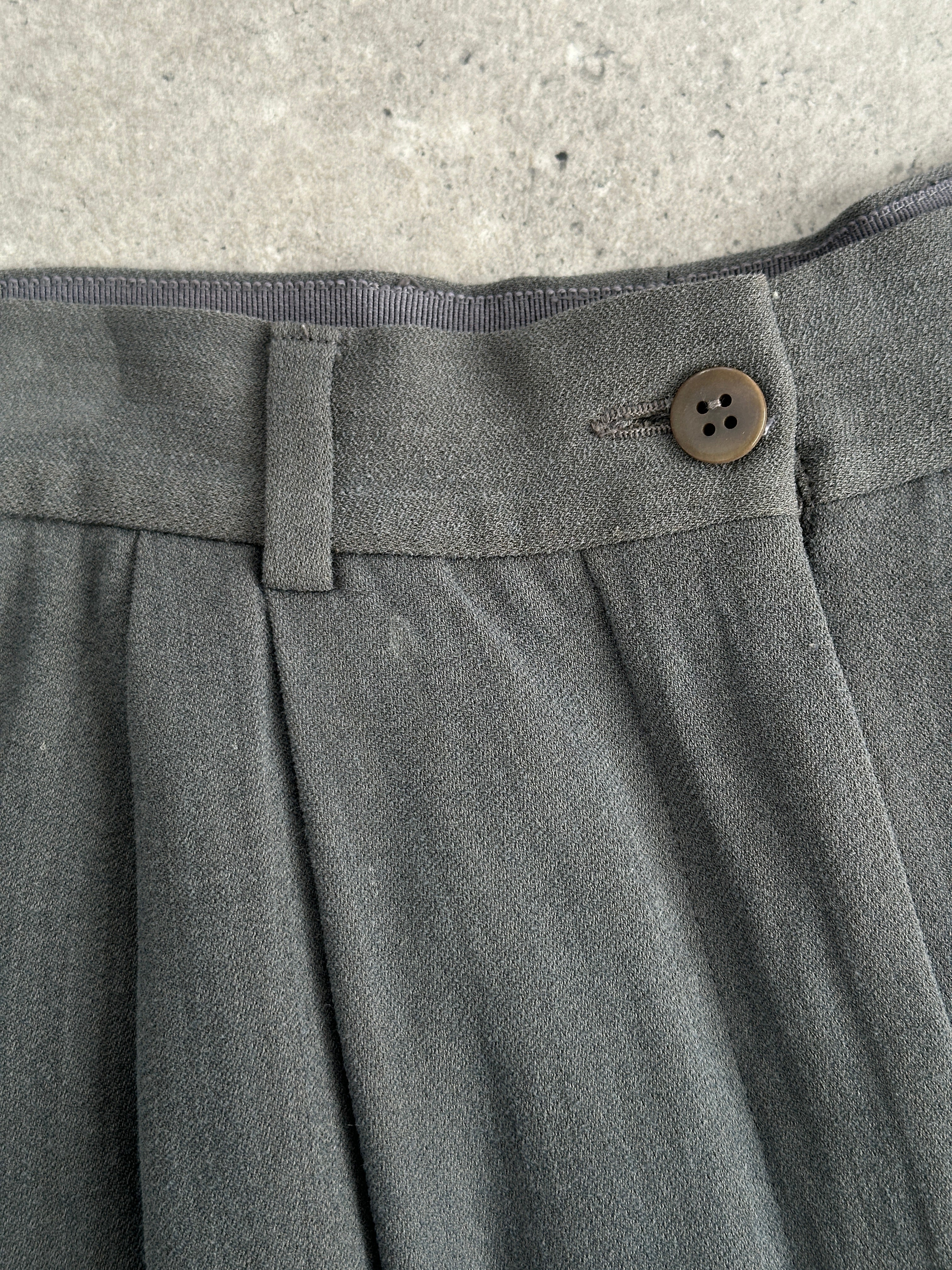 Giorgio Armani high-waisted tapered leg pleated trousers in classic fabric, shown on a model with a neutral background.