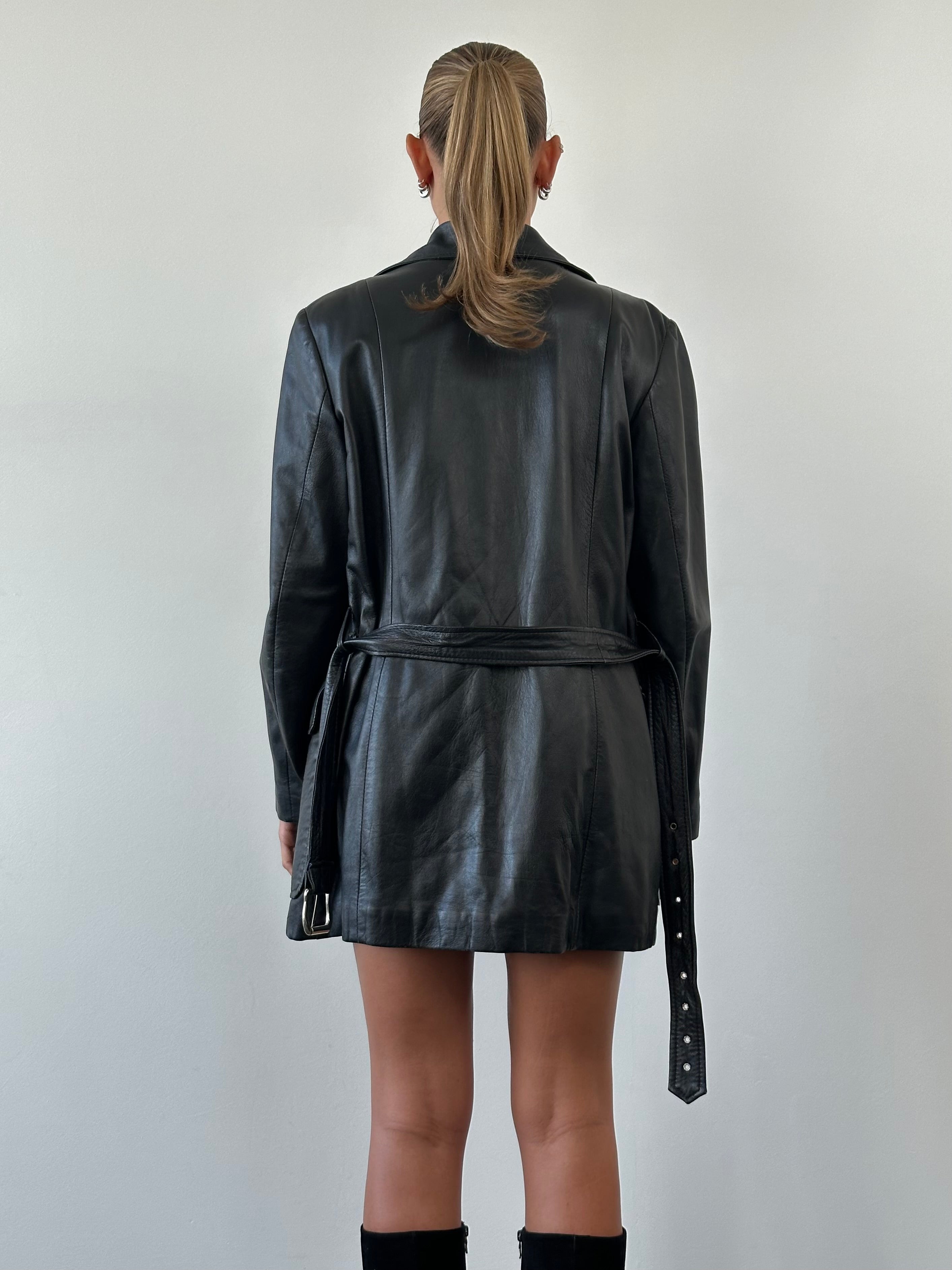 Vintage double-breasted belted leather jacket in smooth leather, displayed on a hanger, size large/extra-large.