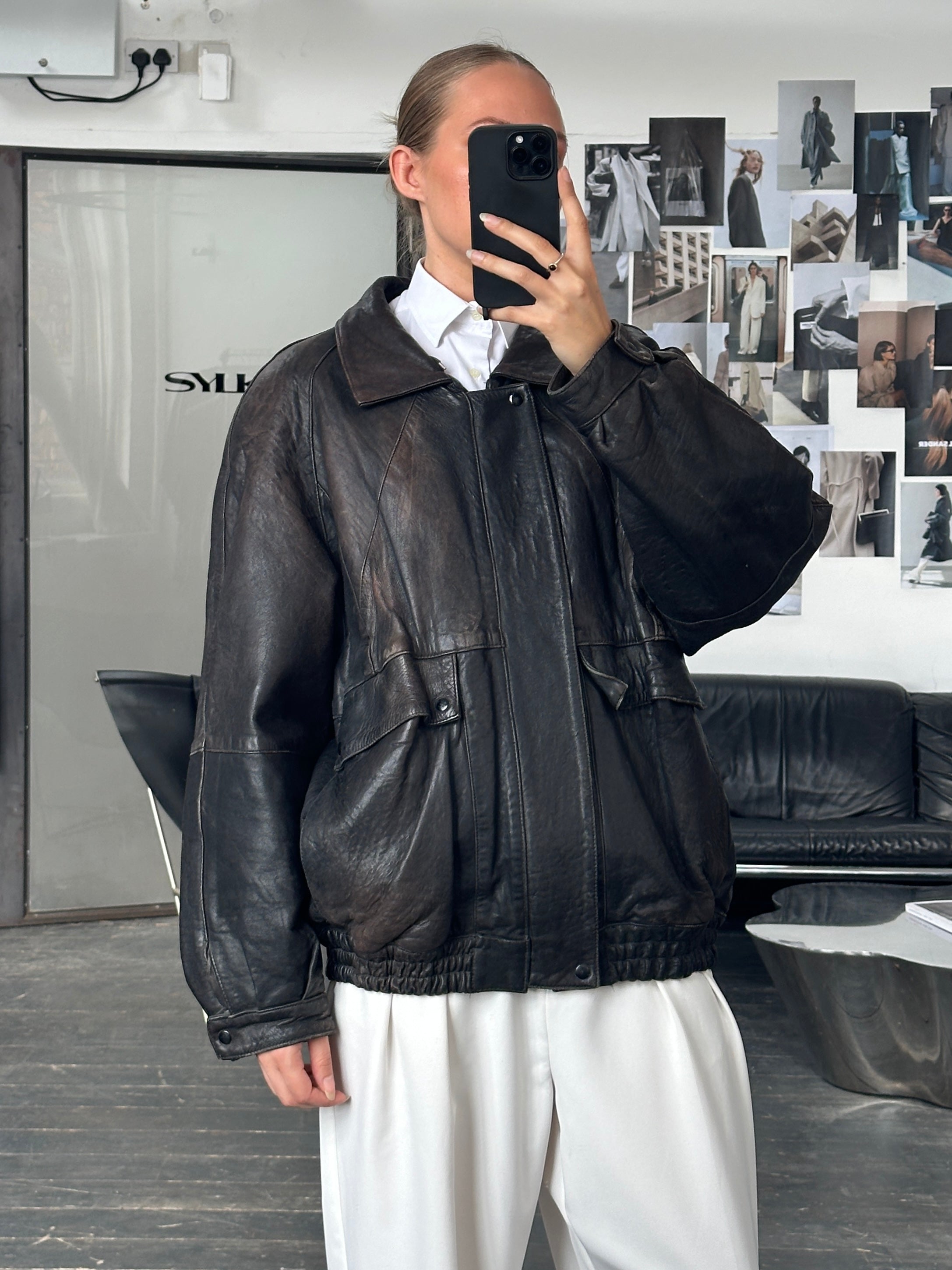 Vintage brand vintage 1980s aged leather bomber jacket in size XL, showing distressed leather and classic bomber style.