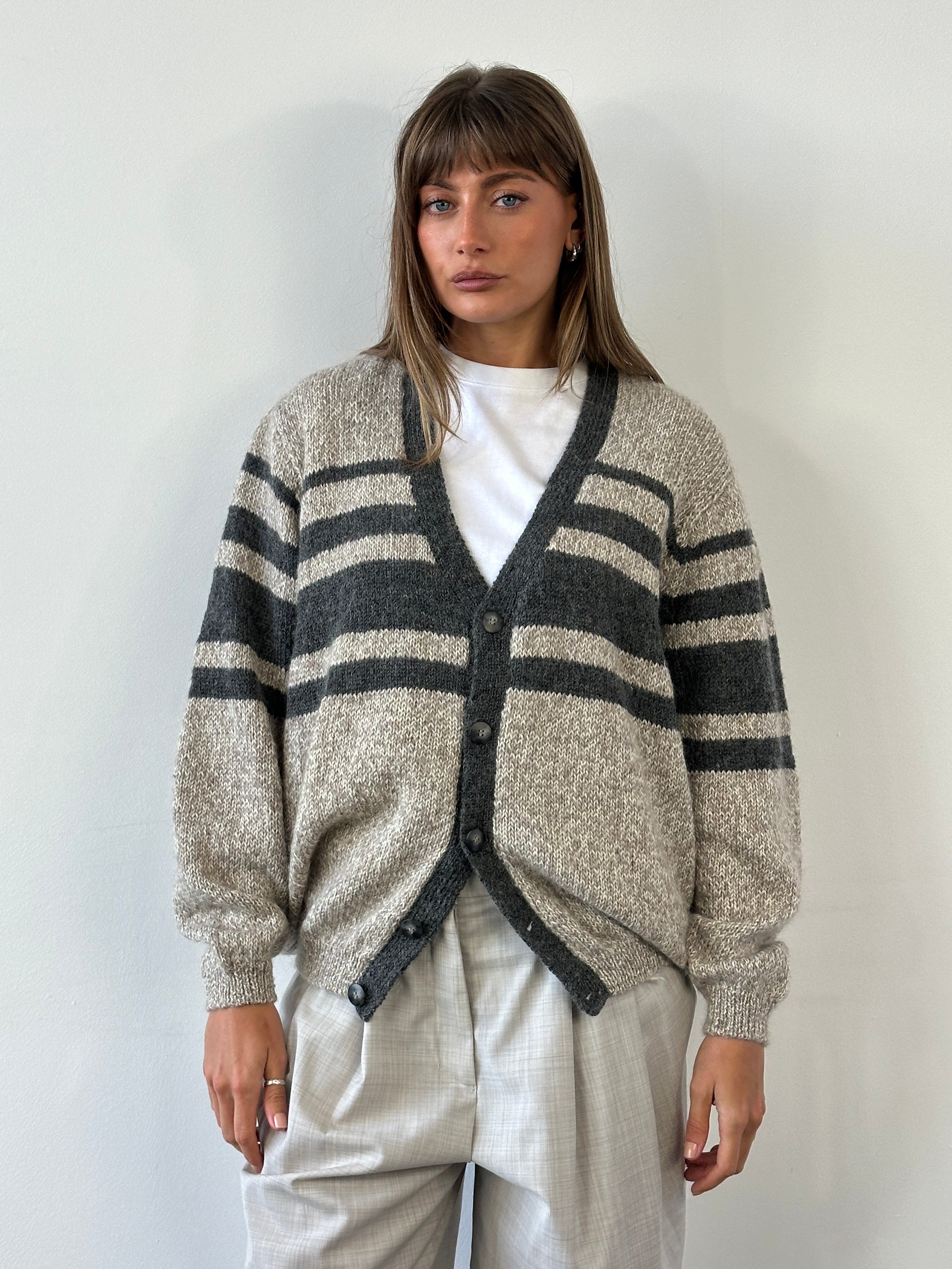 Vintage 1990s pure wool knitted stripe cardigan in size large/extra large, featuring colorful horizontal stripes and a cozy fit.