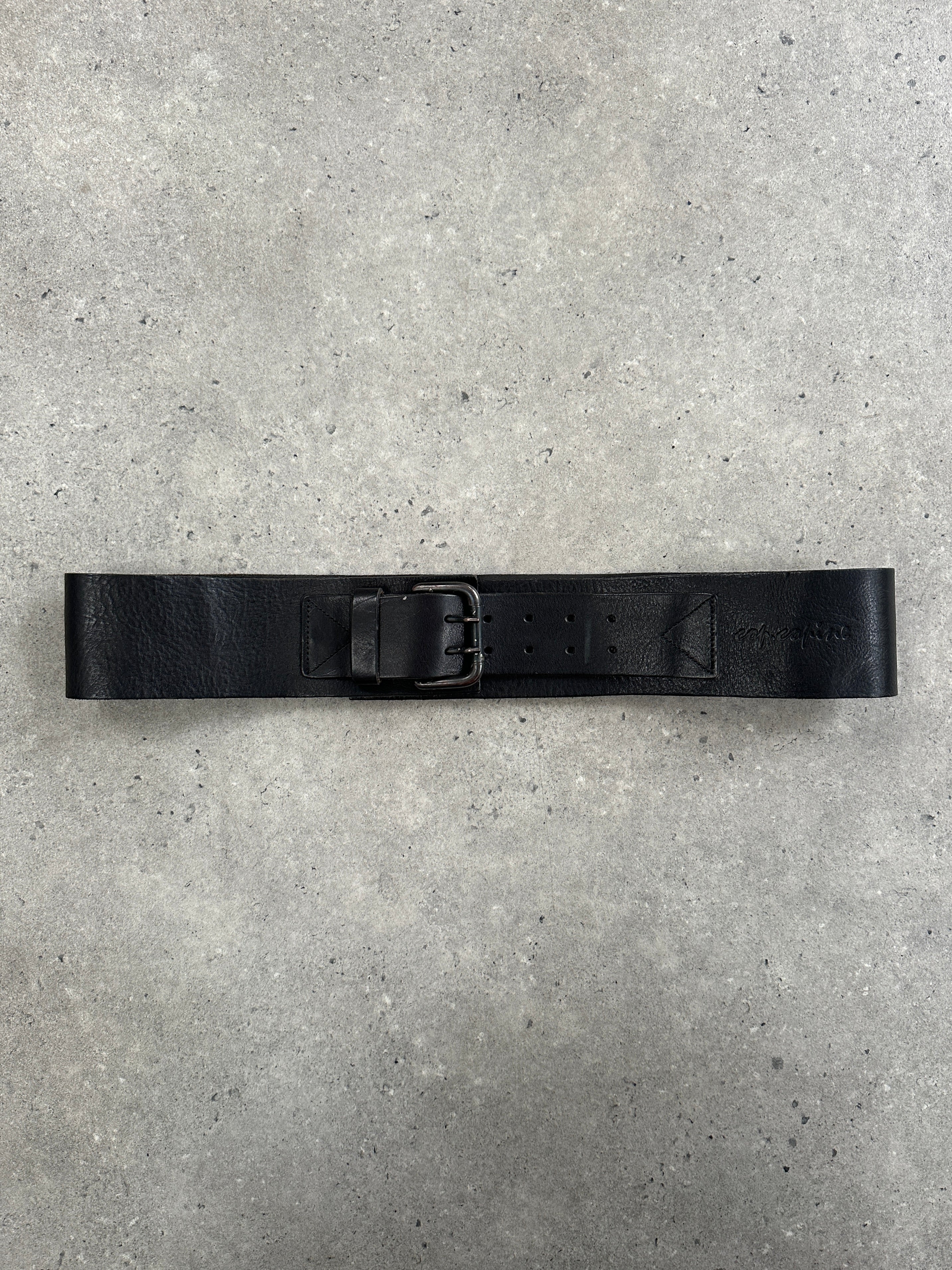 Cop Copine 1990s chunky leather belt in black with silver buckle, displayed flat showing textured leather and belt holes.