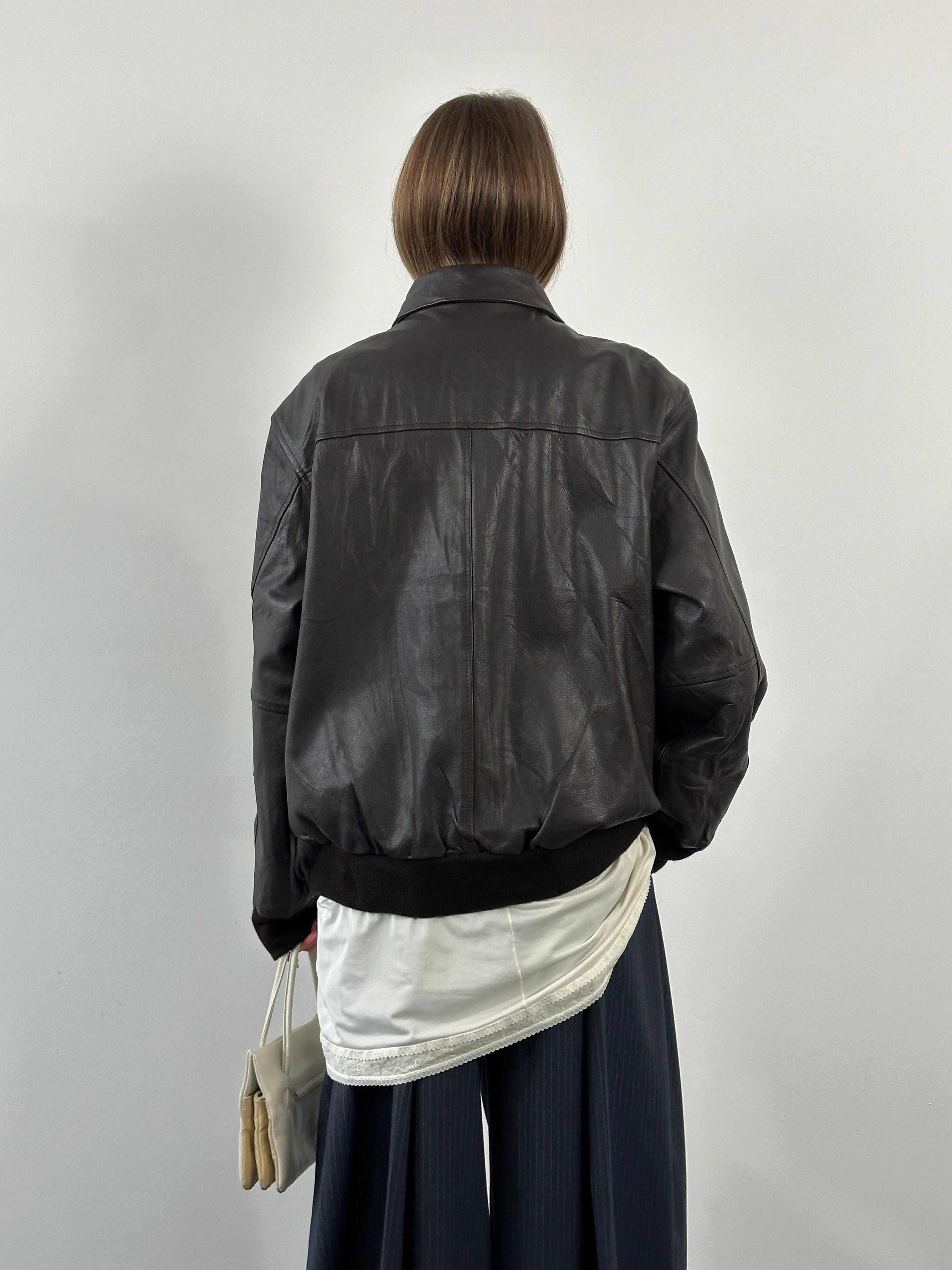 Vintage 1990s leather bomber jacket with concealed placket, size XL, featuring classic design and genuine leather material.