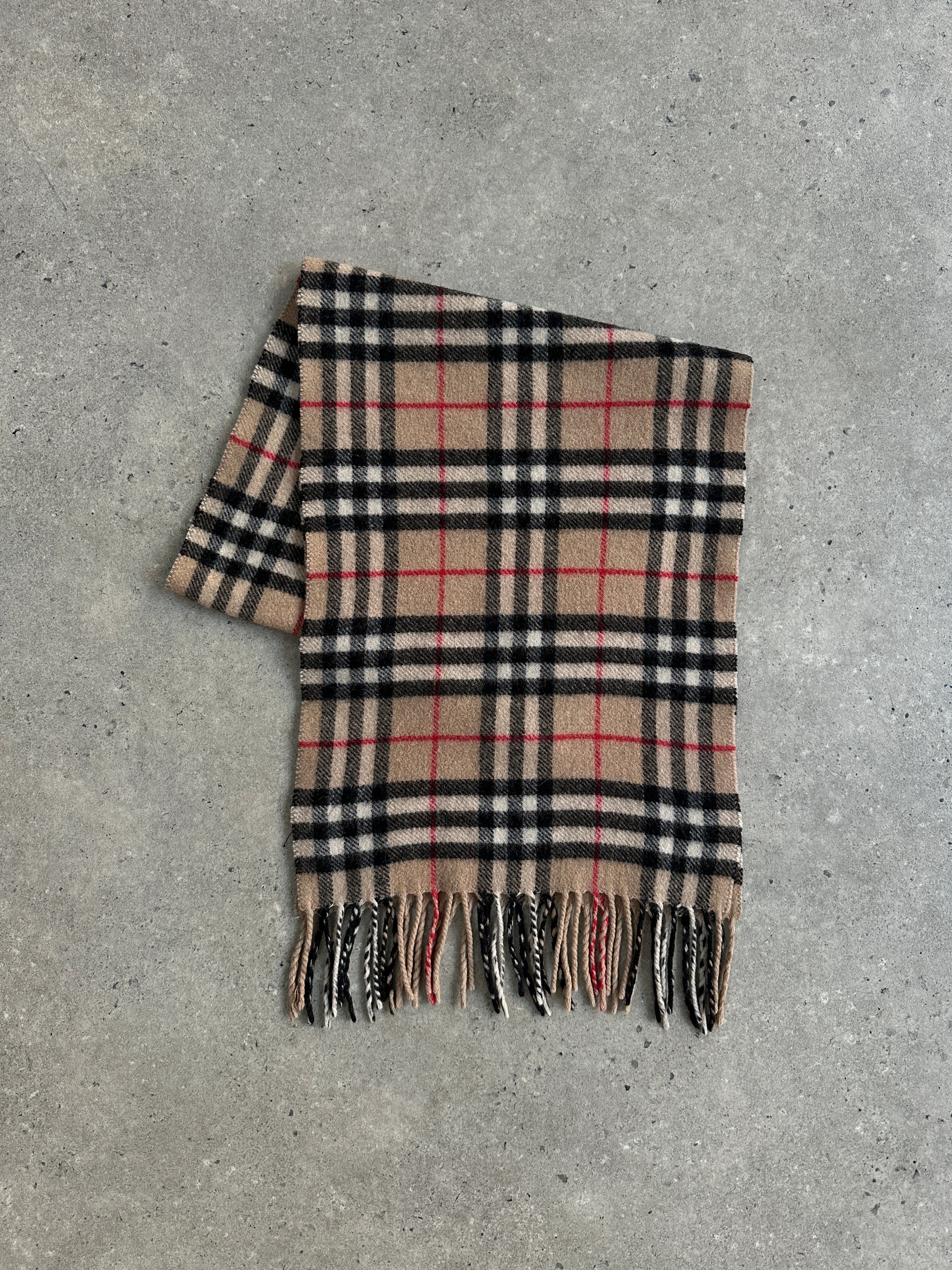 Burberry wool and camel hair Nova Check scarf featuring classic beige, black, and red plaid pattern, draped over a neutral background.