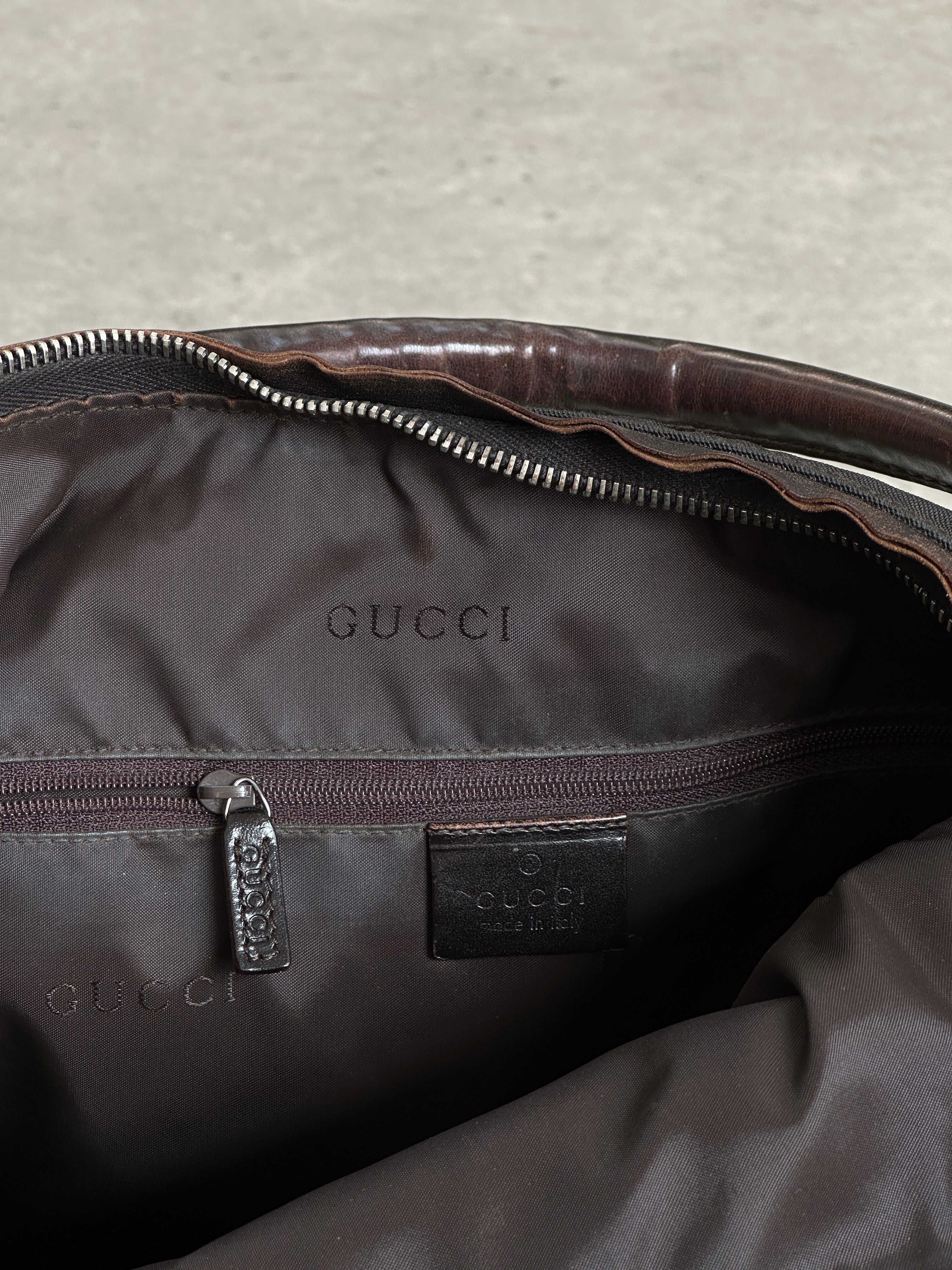 Gucci Canvas Leather Shoulder Bag showing the signature design, adjustable strap, and detailed leather accents.