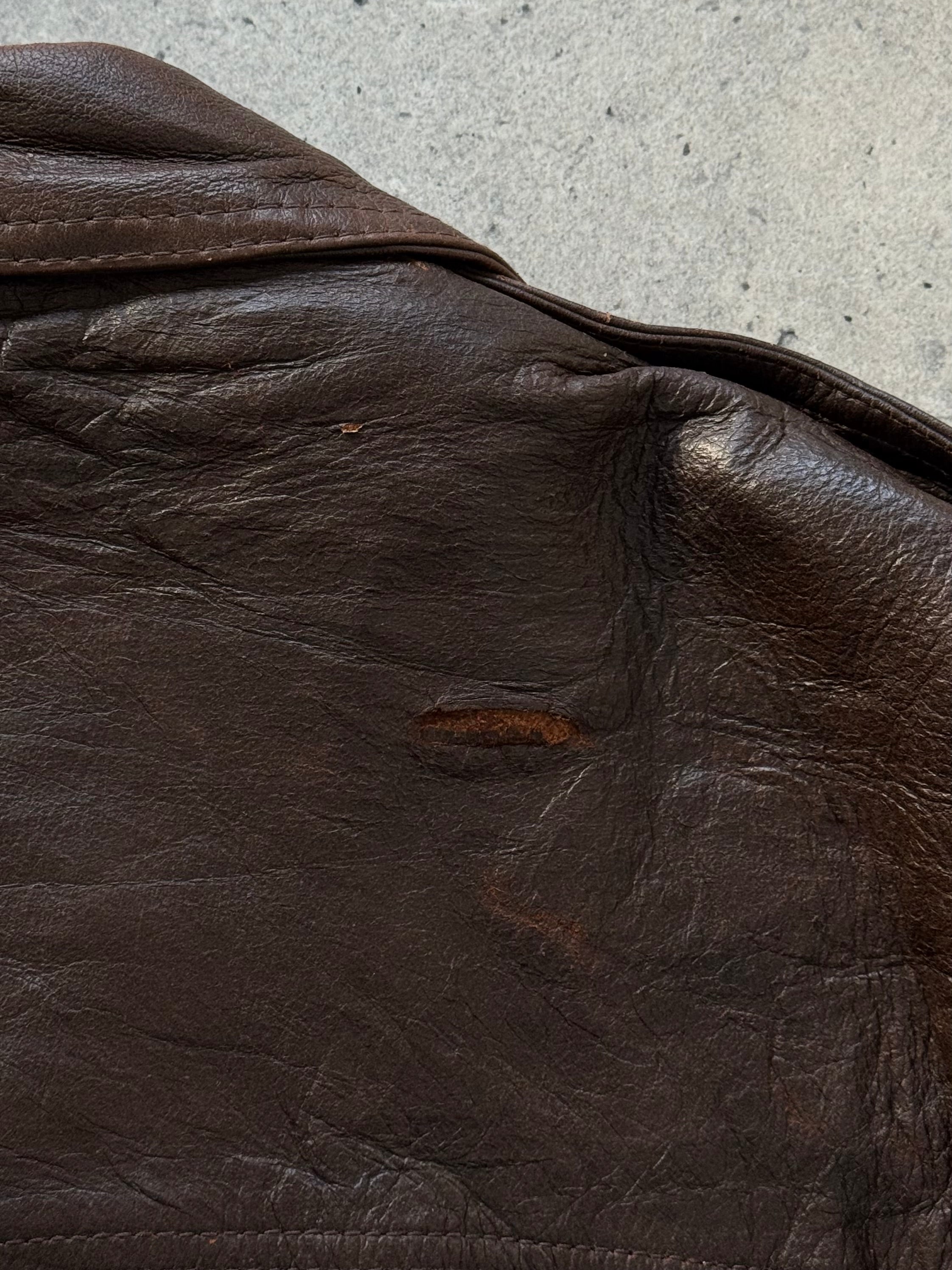 Vintage 1990s distressed leather bomber jacket in XL, showcasing a rugged, worn-in look with classic design details.