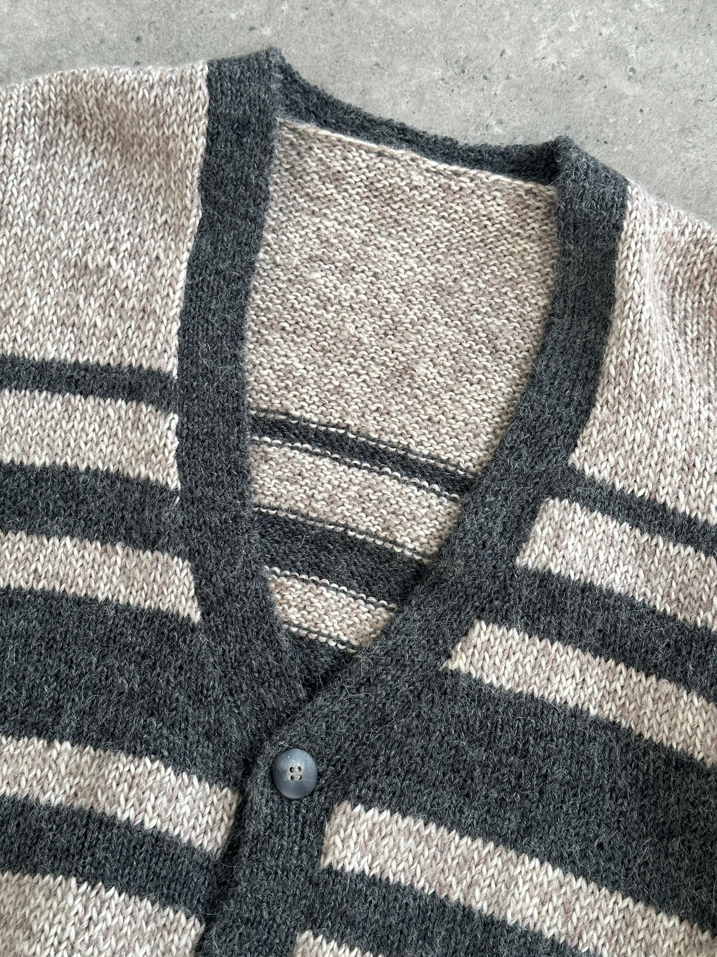 Vintage 1990s pure wool knitted stripe cardigan in size L/XL, featuring colorful horizontal stripes and a classic button-up design.