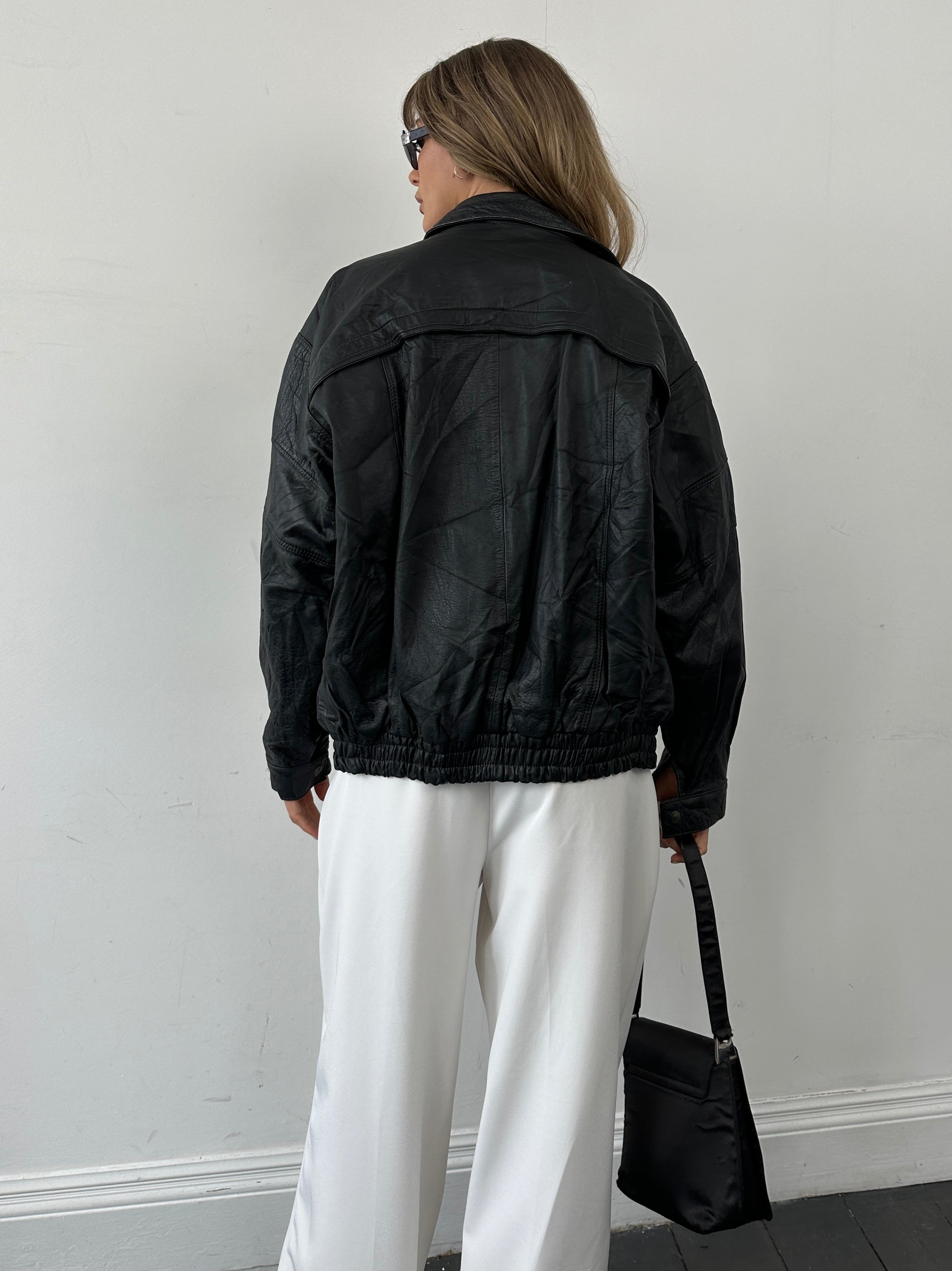 Vintage leather bomber jacket in size M/L, featuring classic design with smooth leather and ribbed collar and cuffs.