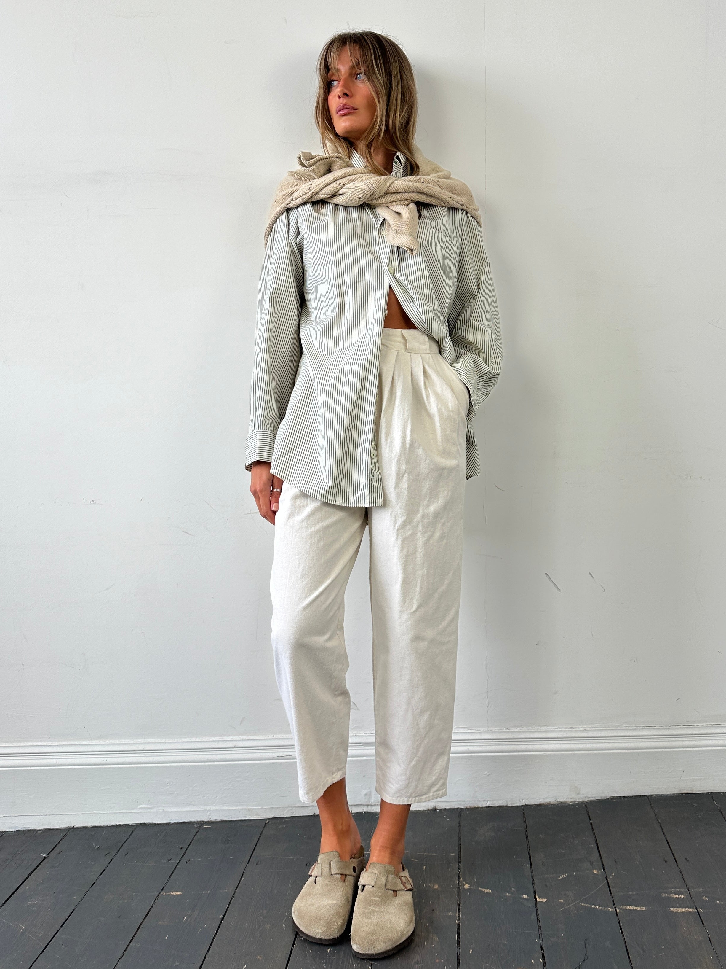 Vintage cotton linen pleated high-waisted trousers in natural beige, showcasing their relaxed fit and tailored design.