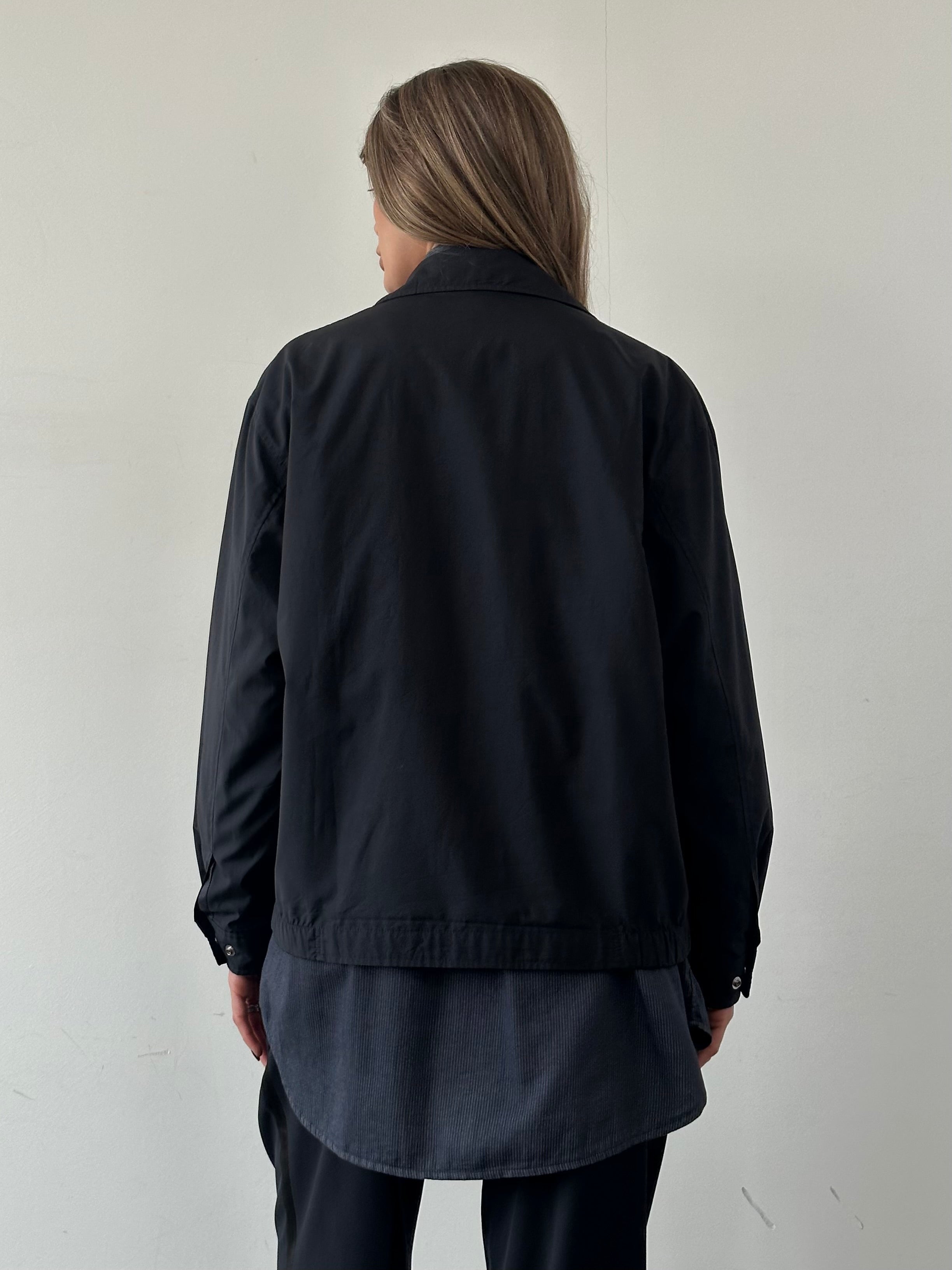 Yves Saint Laurent Pour Homme logo bomber jacket in size M/L, black with YSL branding, front view showing collar and zip closure.