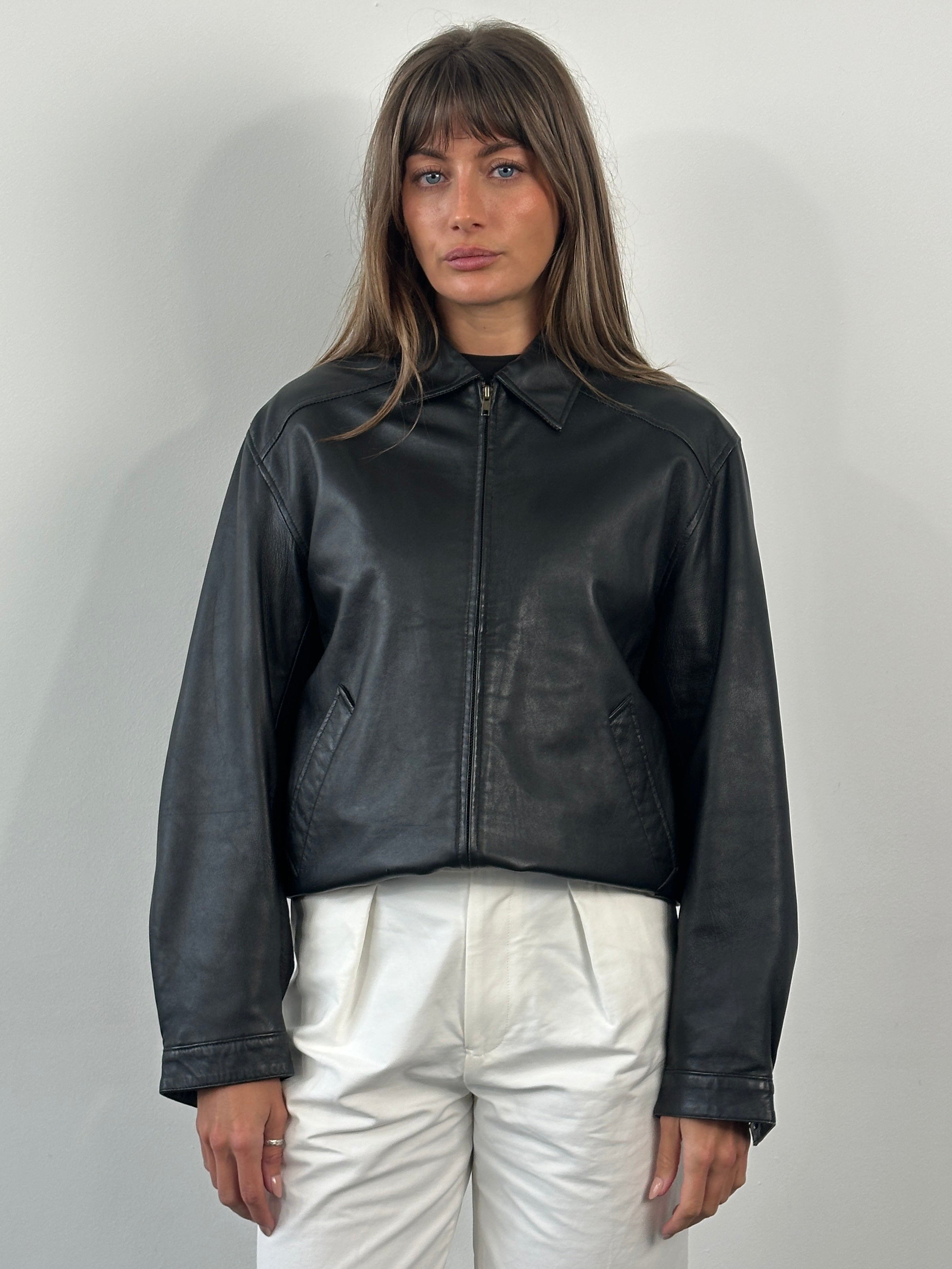 Vintage 1990s leather bomber jacket, size small/medium, featuring classic design and rugged leather texture.