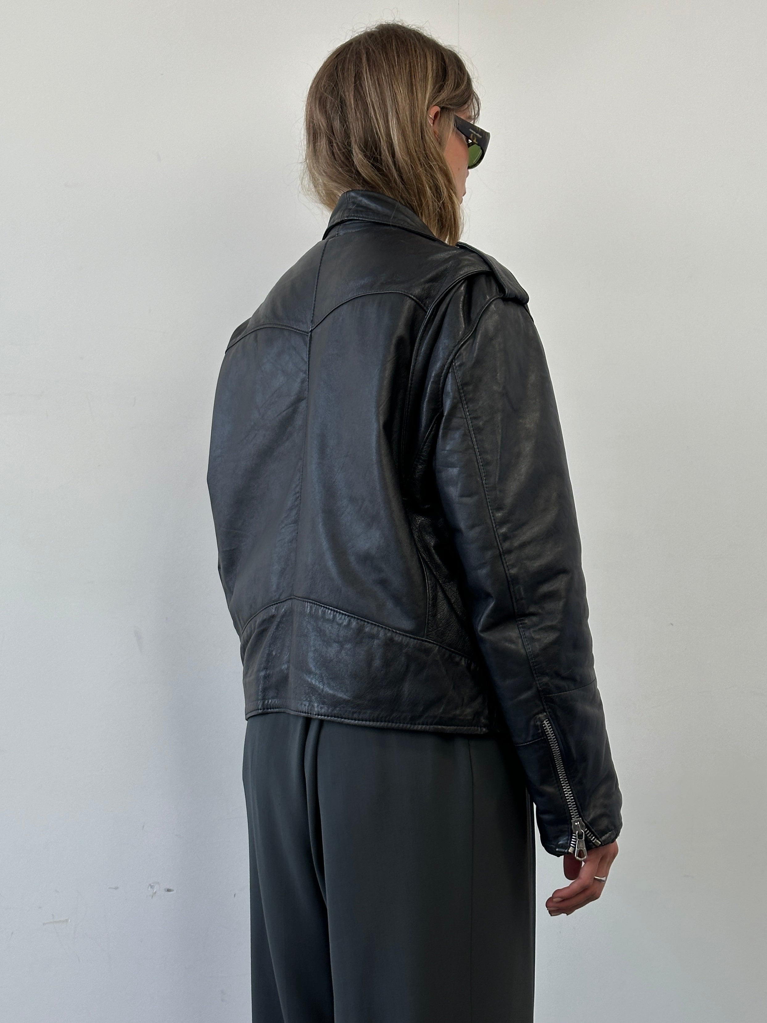 Vintage leather biker jacket in size M/L, featuring classic design, rugged texture, and stylish details.