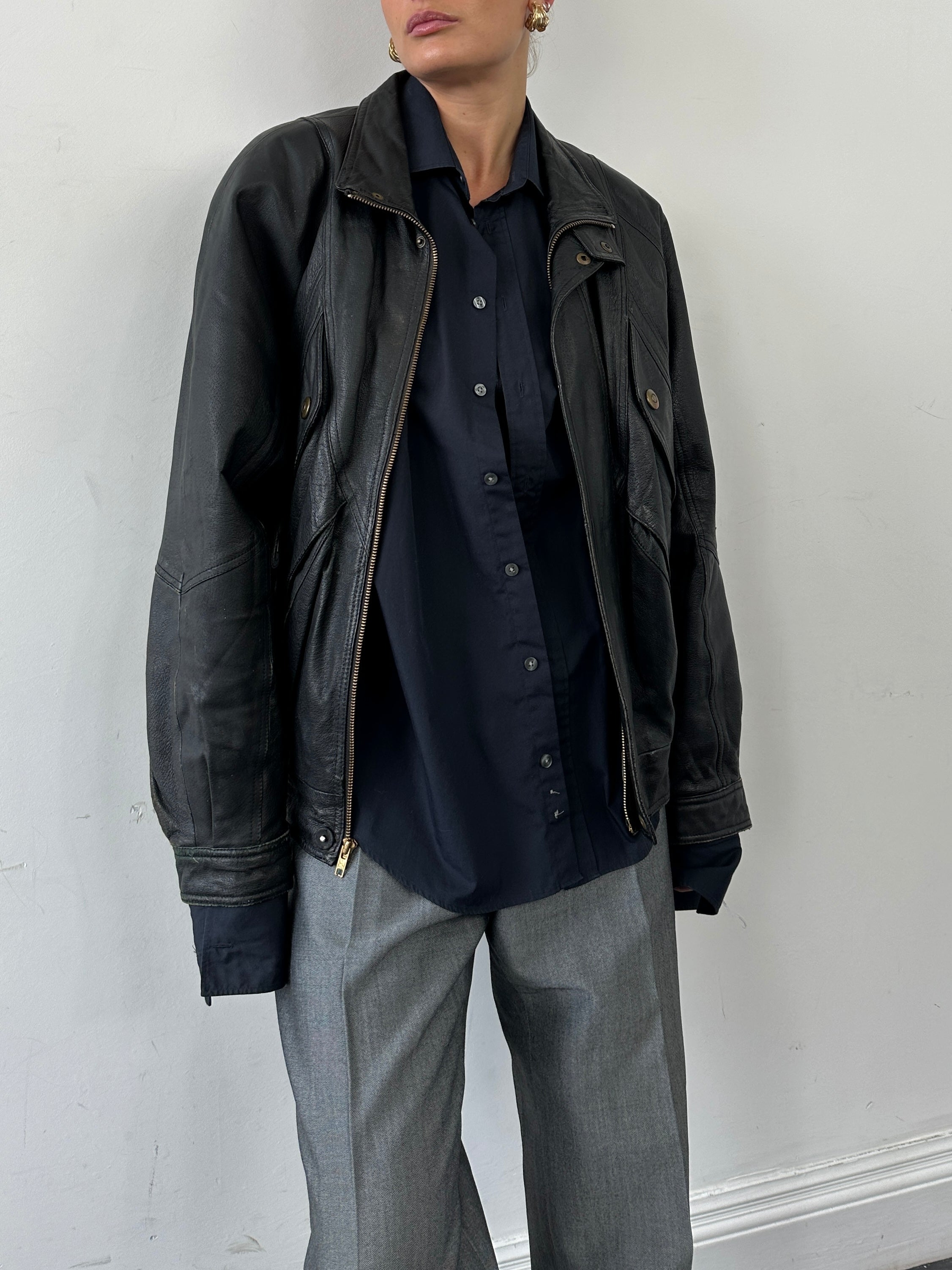 Vintage leather bomber jacket in size L/XL, featuring classic design, ribbed cuffs, and a front zipper for a timeless look.