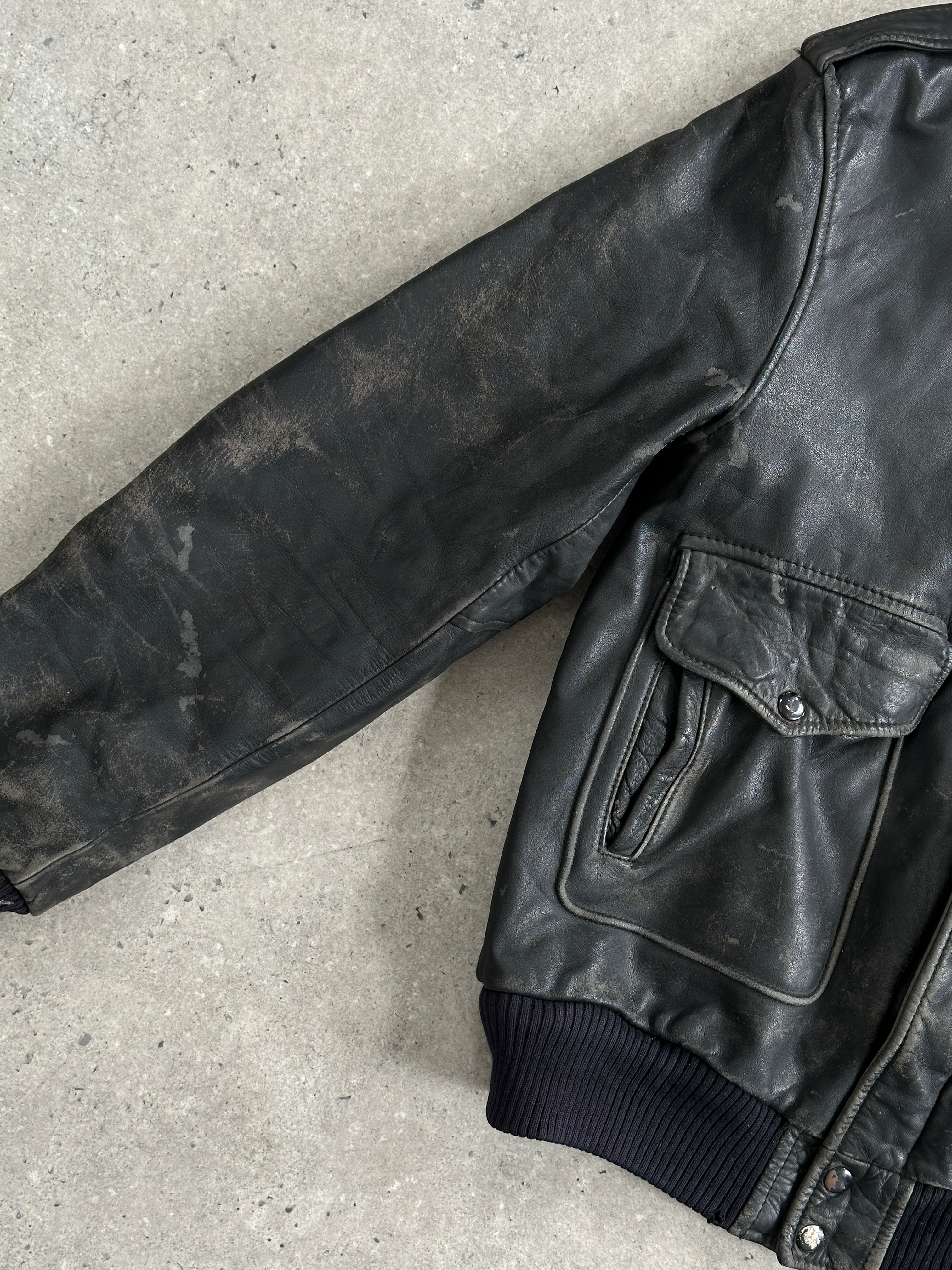 Vintage distressed leather bomber jacket in size M/L with rugged style and classic design, featuring worn-in leather and vintage details.