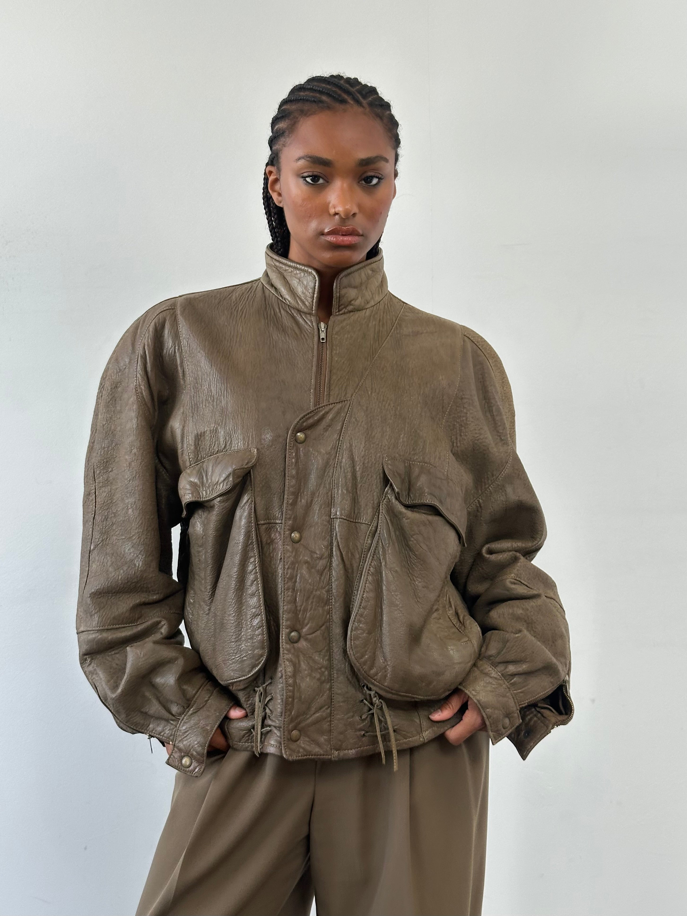 Vintage leather moto jacket from the 1980s, size large, featuring classic design and detailed stitching.