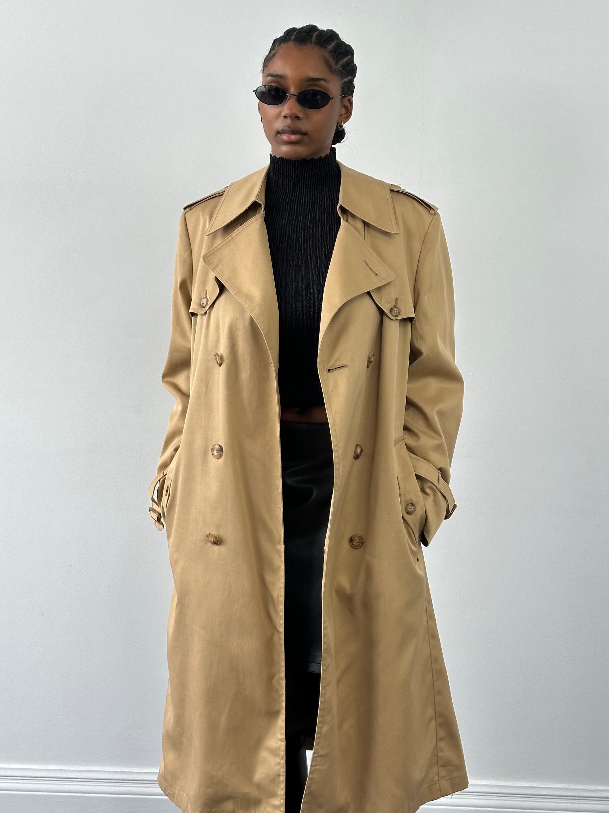 Christian Dior Paris 1980s cotton double-breasted trench coat in beige, shown on a hanger with classic belt and lapel details.