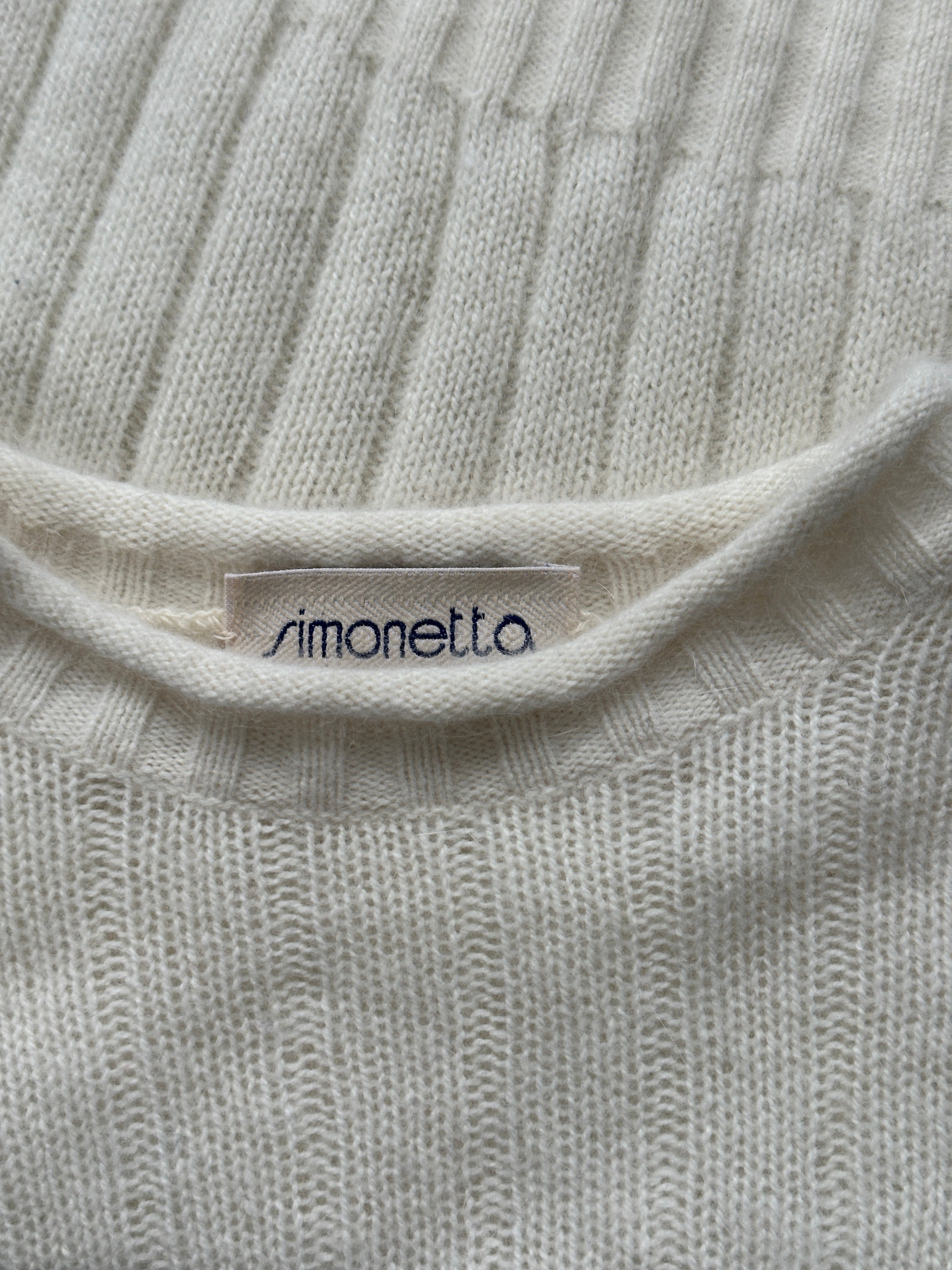 Vintage 1990s angora wool cropped jumper, soft and cozy, in a classic style, shown on a hanger against a neutral background.