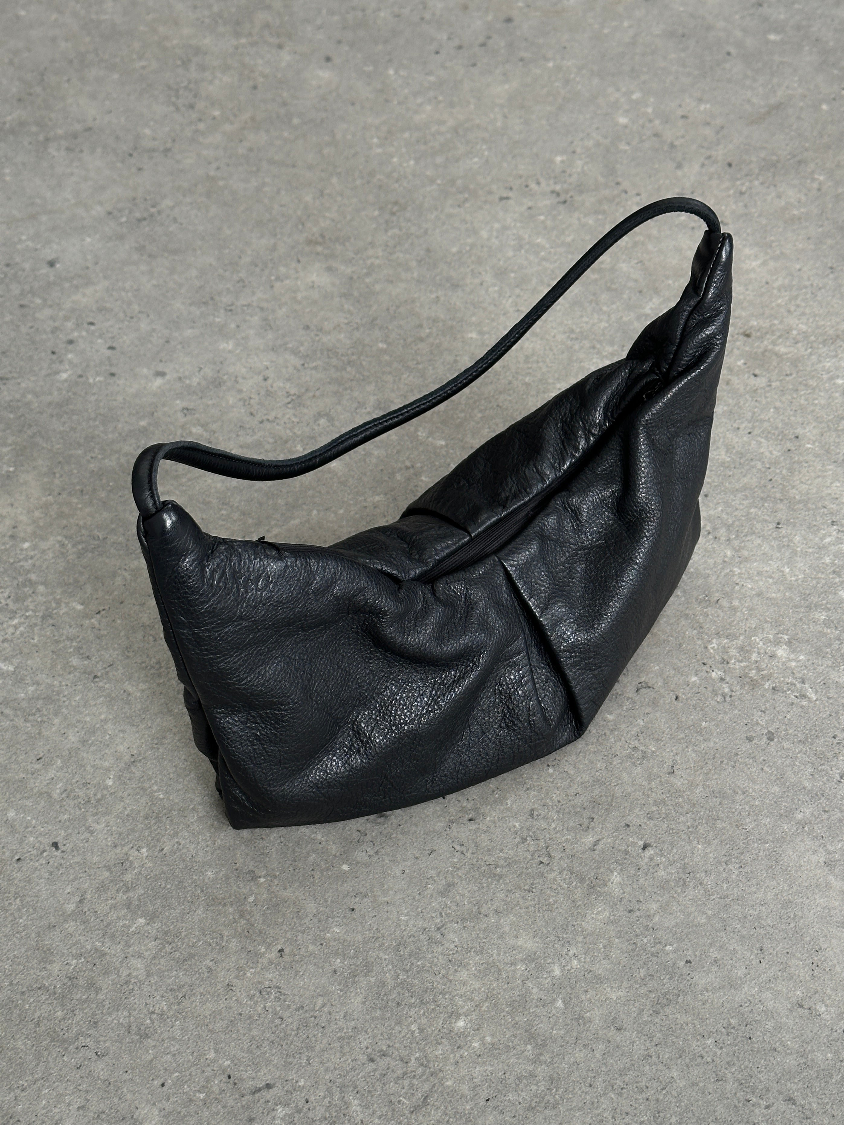 MAX & Co leather crescent shoulder bag with adjustable strap and sleek design, shown in the image.