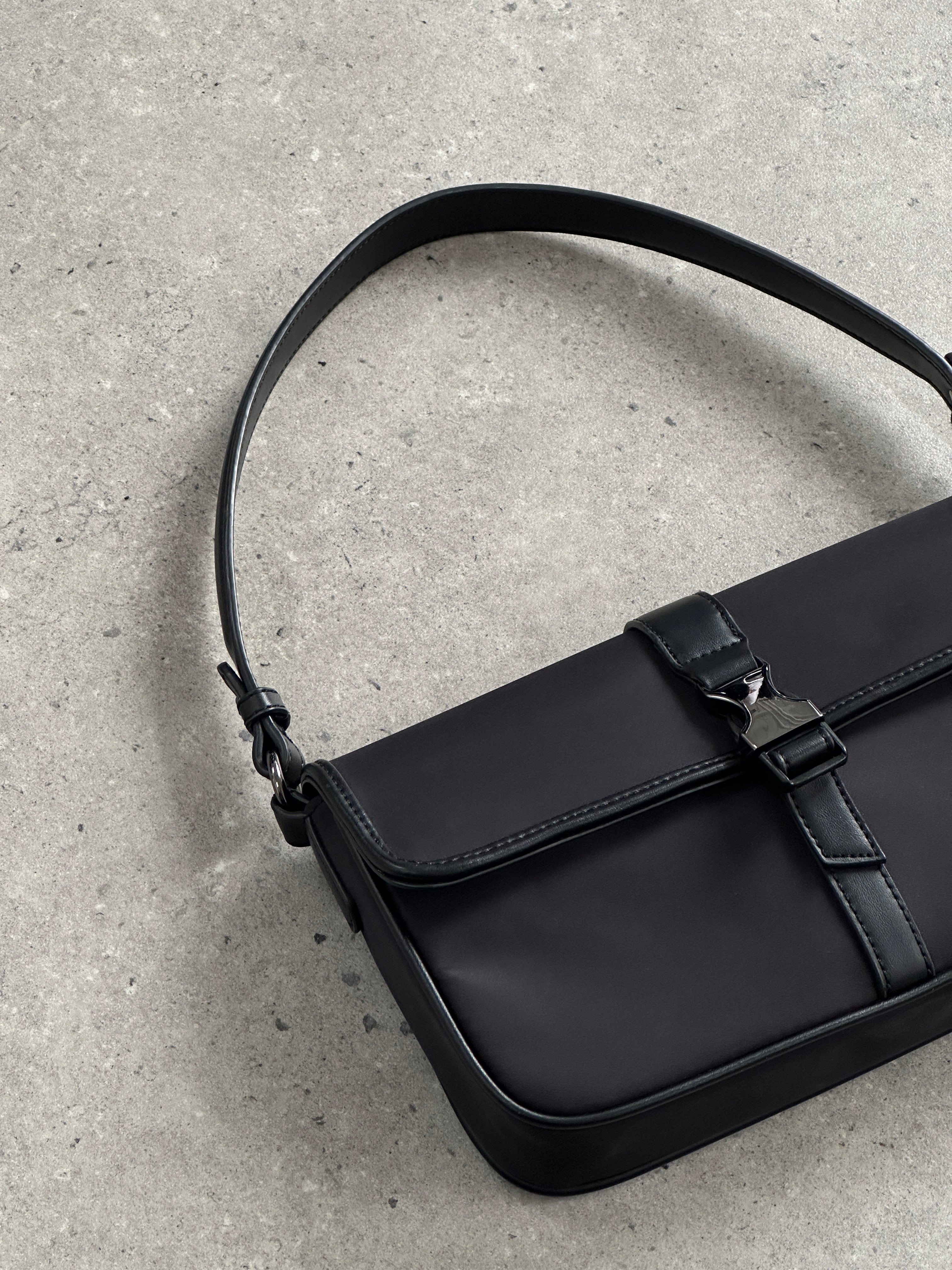 Pierre Cardin nylon shoulder bag with hardware, featuring sleek design and adjustable strap for versatile everyday use.