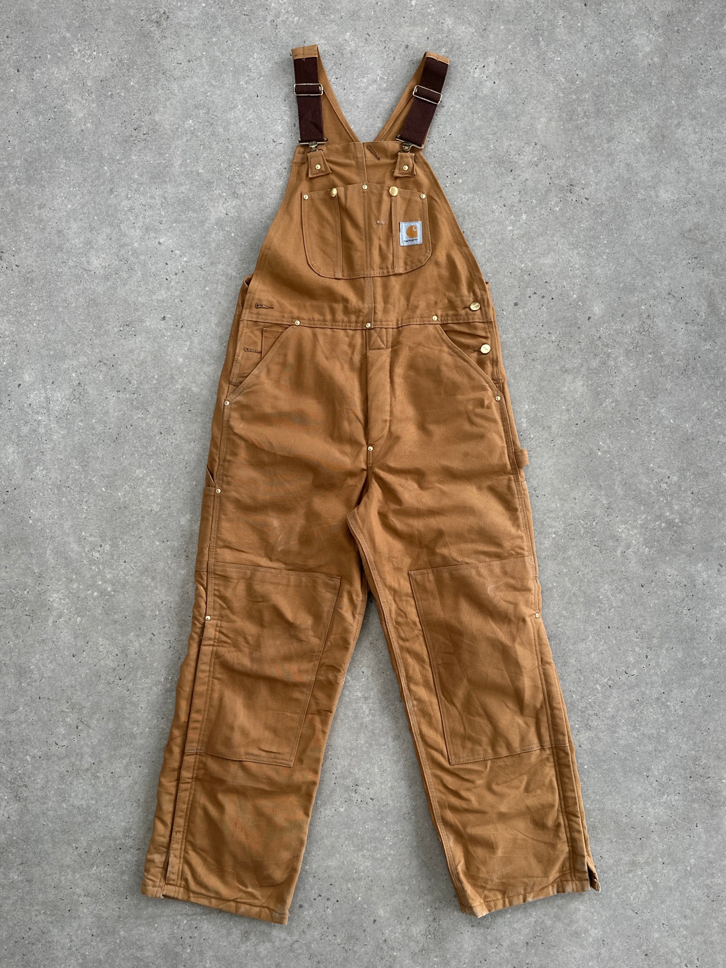 Carhartt pure cotton dungarees in size M showing durable fabric, classic design, and adjustable straps on a neutral background.