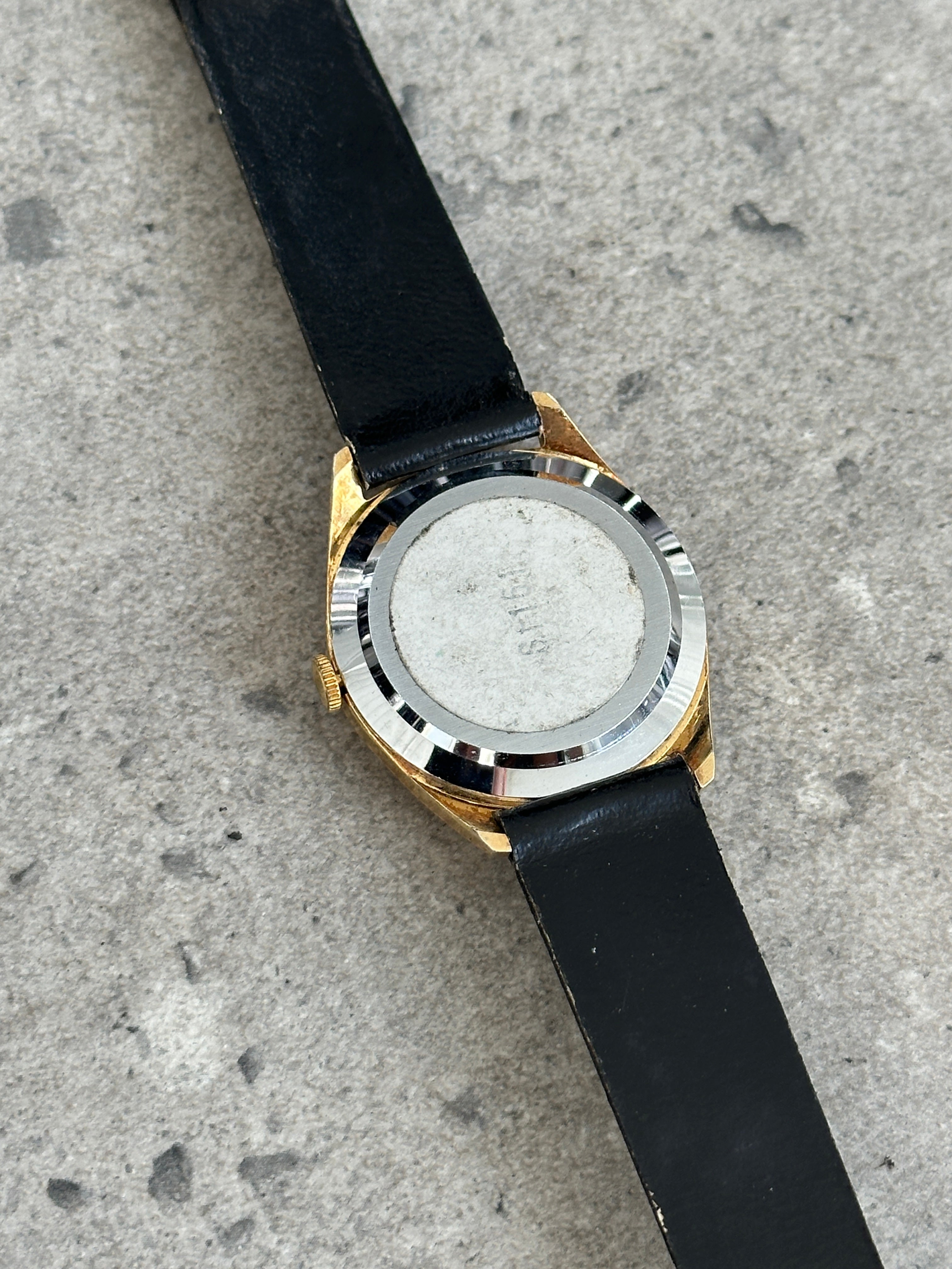 Vintage 1980s Swiss Made mechanical leather watch with a classic round face and leather strap, showcasing retro watch design.