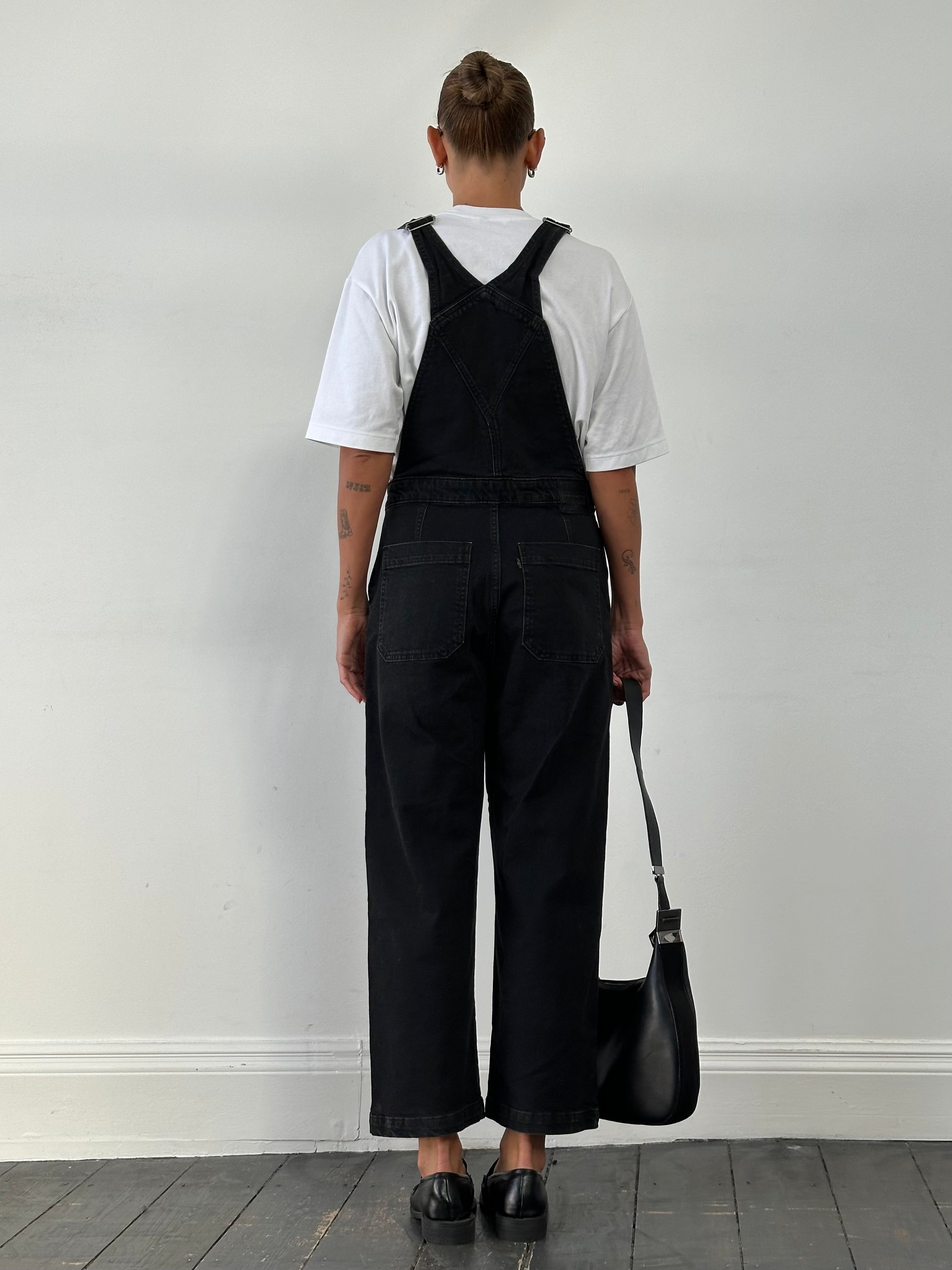 Levi’s premium denim dungarees in size M, featuring classic blue denim fabric and adjustable straps on a hanger.