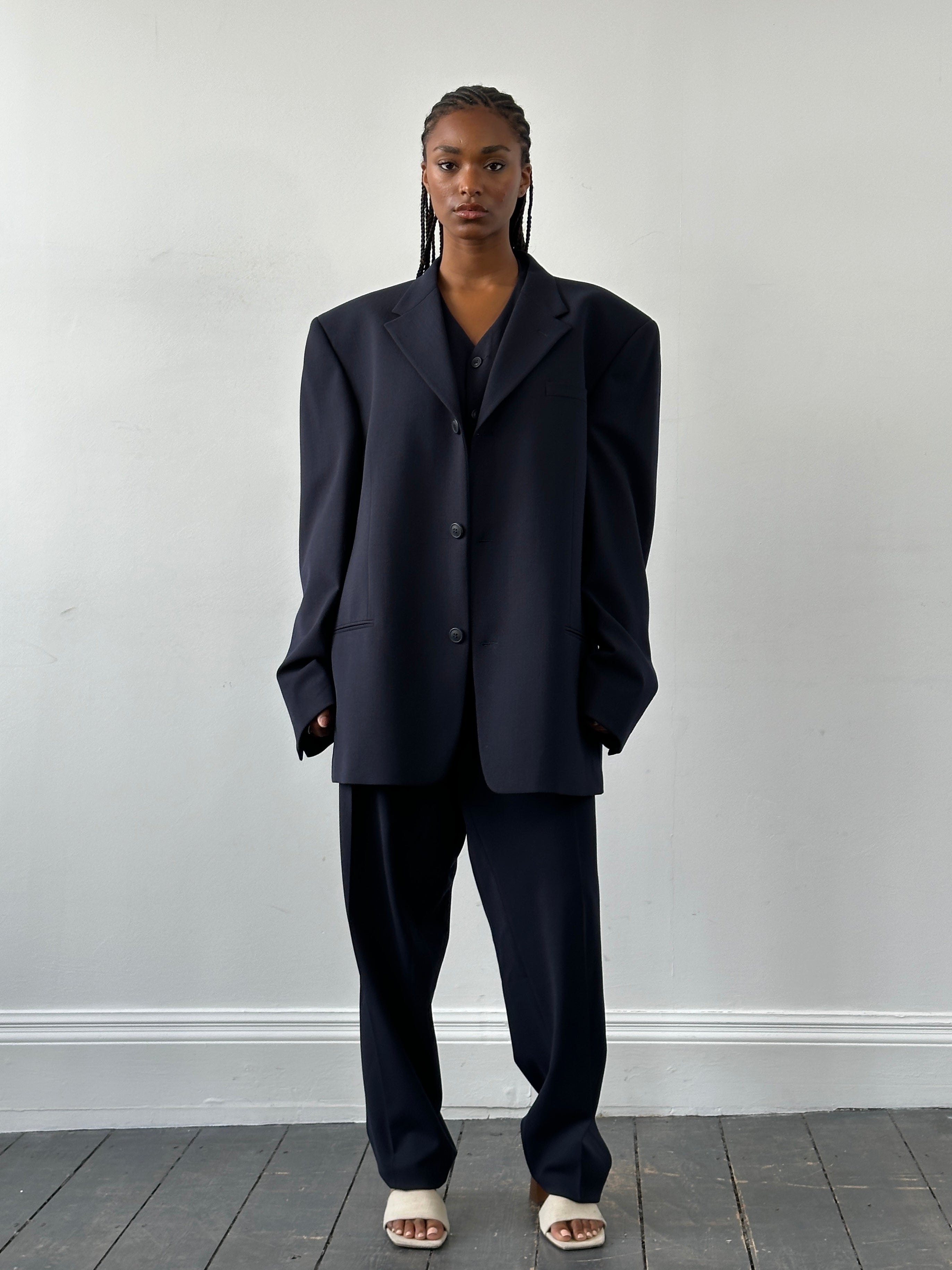 Versace Versus 1990s three-piece suit in navy with patterned blazer, matching trousers, and vest, size 48R/W32, on hanger.