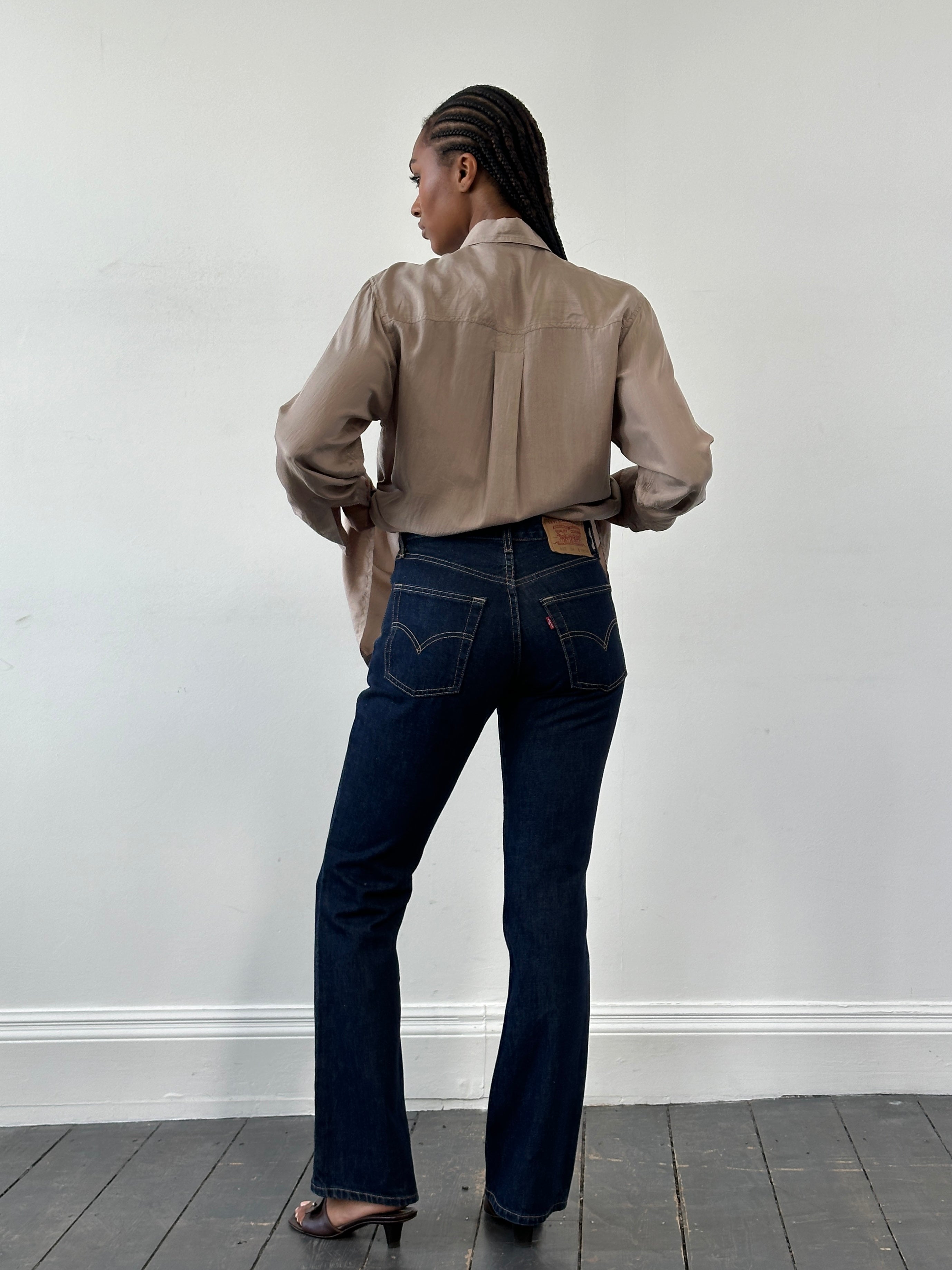 Levi’s 525 mid-rise denim bootcut jeans in W26, showing classic blue wash and fitted style with slight flare at the hem.