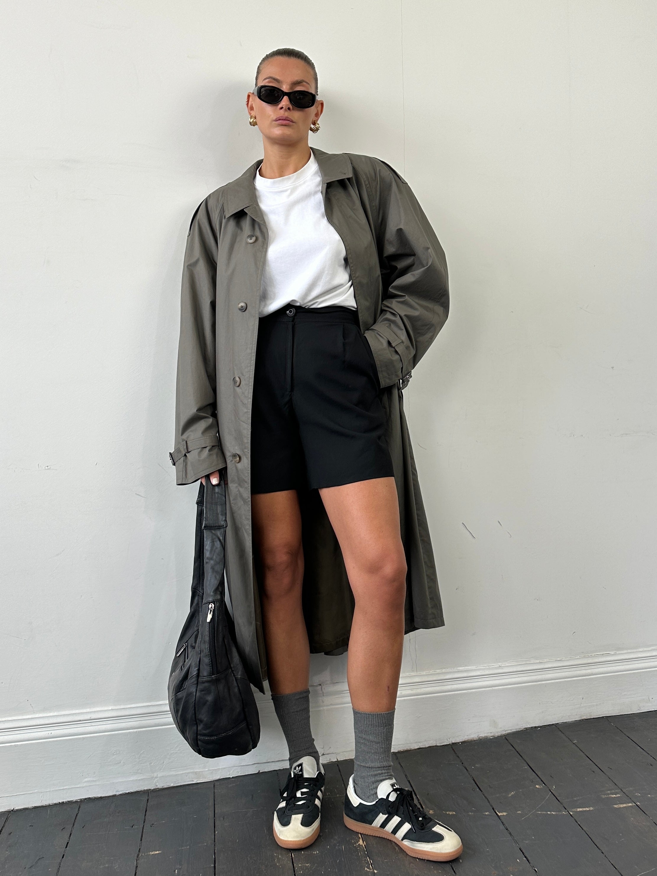 Vintage oversized trench coat with concealed placket, belted waist, in classic style, shown in olive green fabric.