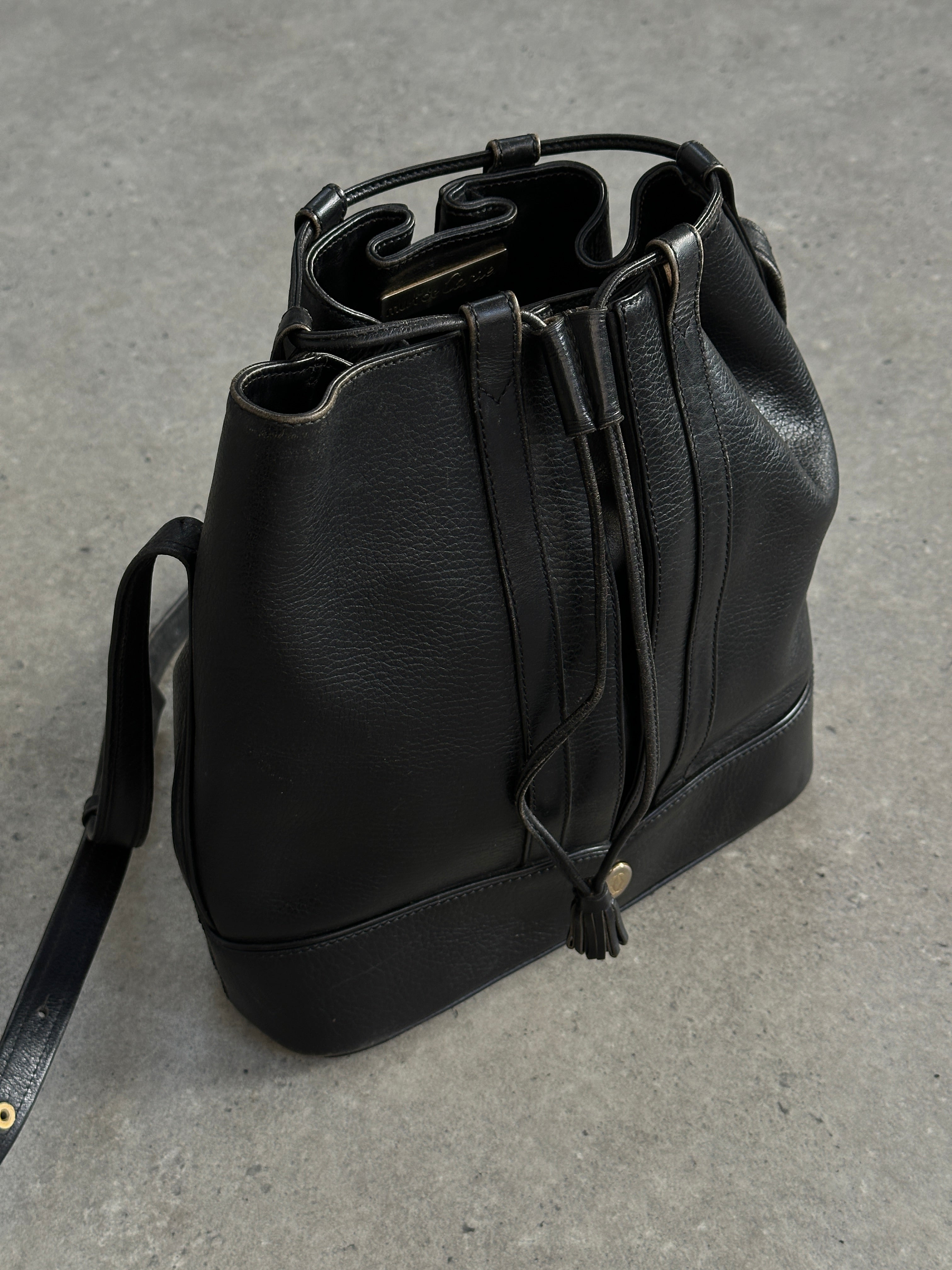 Cartier 1980s leather bucket bag with drawstring closure and gold-tone hardware, featuring a vintage, stylish design.