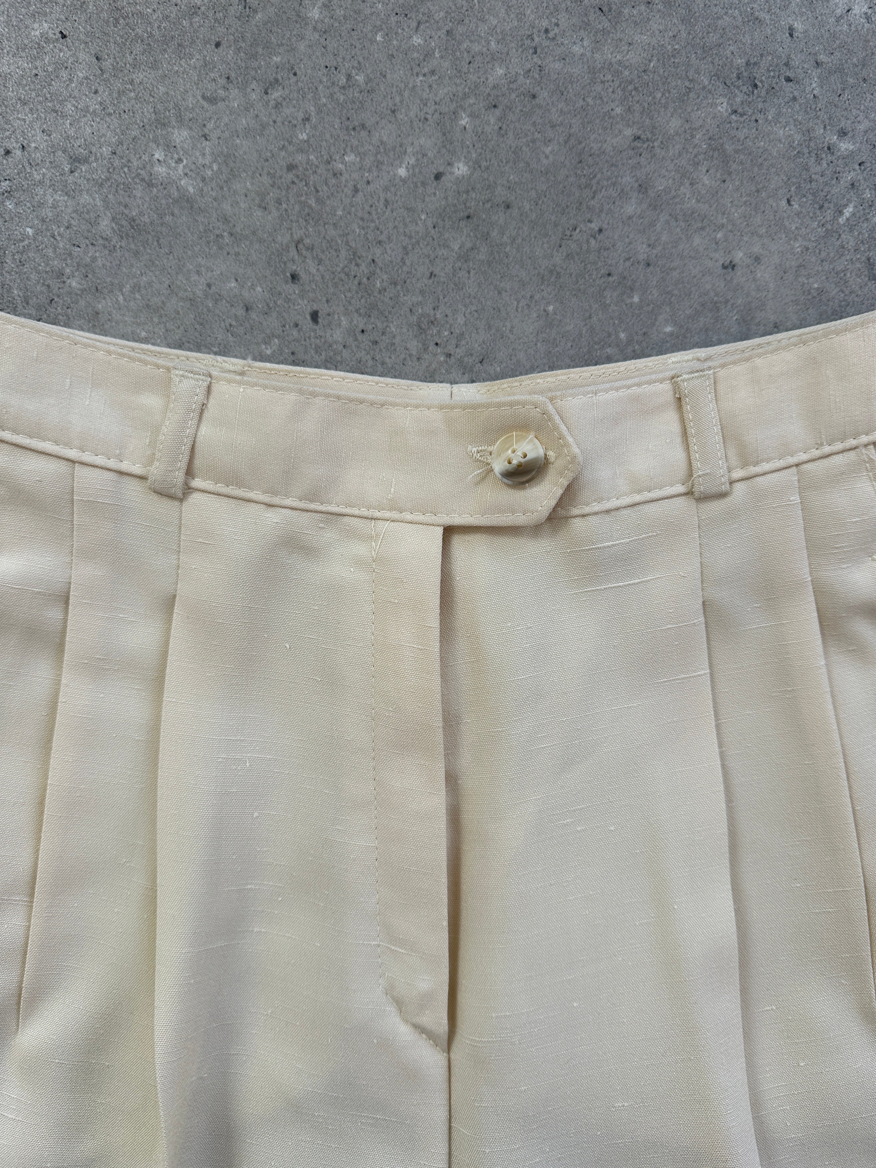 Vintage 1990s high-waisted tailored trousers with straight leg fit, shown in classic dark fabric with detailed waistband and pockets.