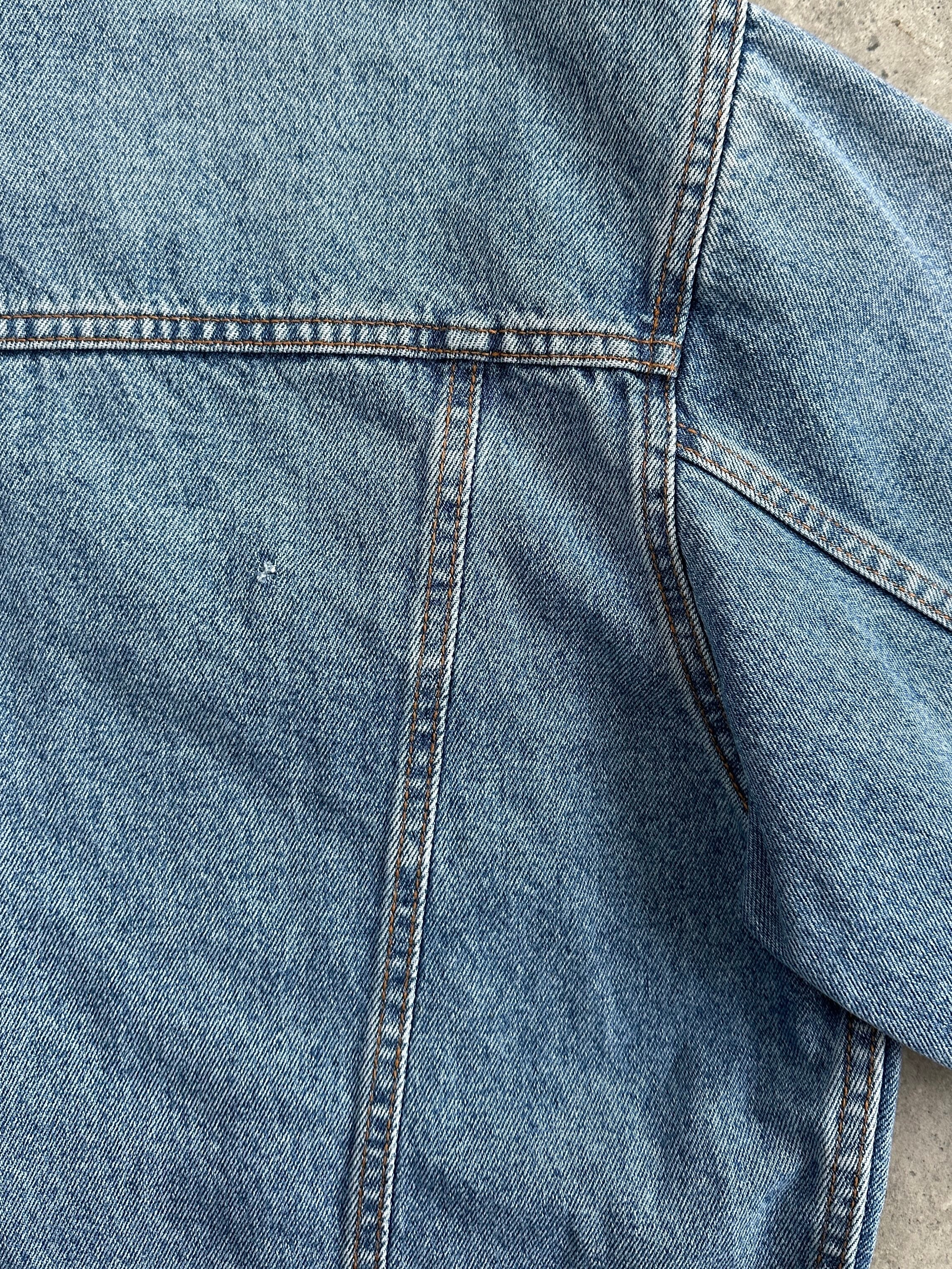 Vintage oversized denim jacket in XL style, featuring classic blue denim and relaxed fit, displayed on a hanger.