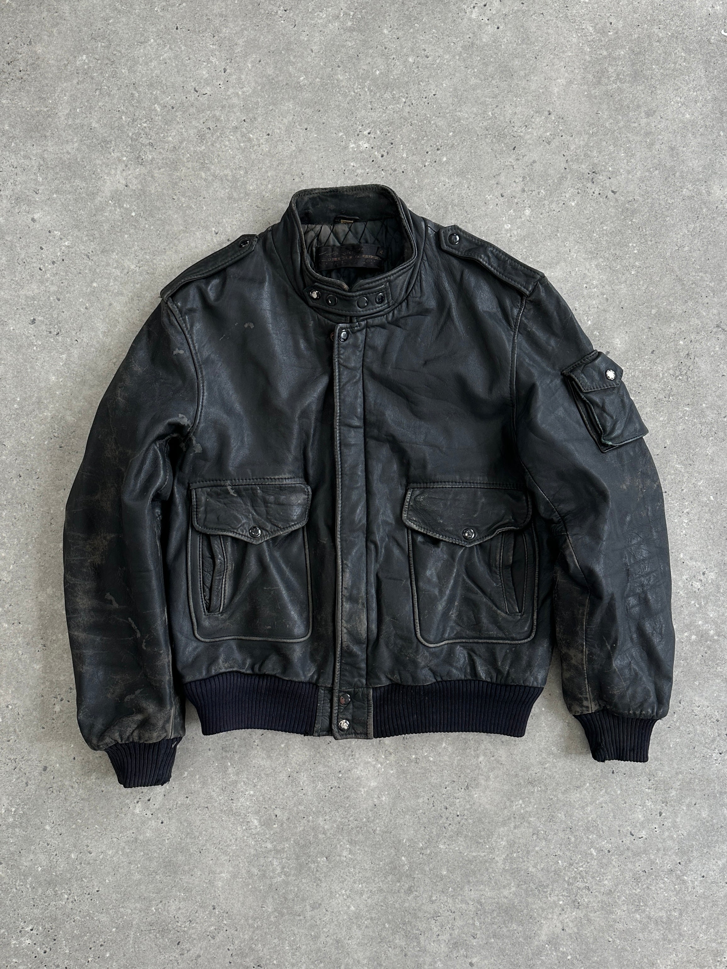 Vintage distressed leather bomber jacket with ribbed cuffs and collar, featuring a classic, rugged style in brown leather.