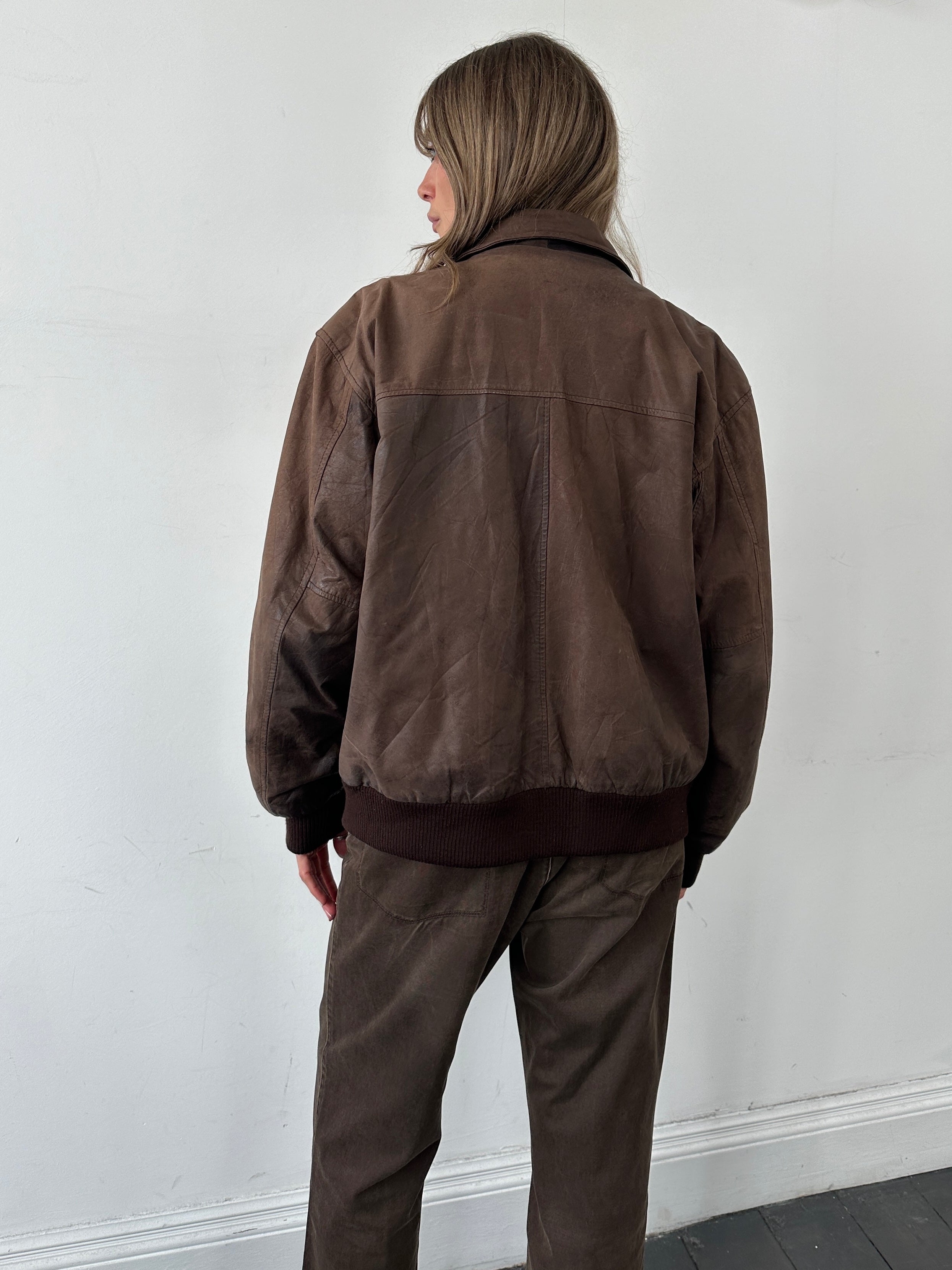 Vintage leather bomber jacket in size large, featuring classic design, ribbed cuffs, and a smooth leather finish.